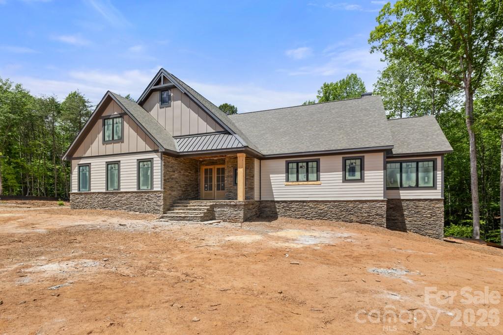Stunning custom new construction on 1.6 private wooded acres located in The Preserve on Grassy Creek, showcasing exceptional craftsmanship and thoughtful design throughout. Beautiful random-width 3” & 5” natural white oak hardwood flooring throughout the home. Impressive open-concept great room and kitchen feature coffered ceilings, gas log stone fireplace, and dramatic Andersen 400 Series sliding glass door with fixed picture window opening to expansive covered porch with composite decking, underdeck waterproofing system, and cedar tongue-and-groove ceiling—perfect for seamless indoor/outdoor living. Chef’s kitchen offers oversized island with seating, farmhouse sink, quartz countertops, custom cabinetry, pantry, and high-end KitchenAid Superba appliances. Main level features 10’ ceilings, crown molding, arched entryways, 8’ solid wood doors, and 2x6 exterior wall construction. Cathedral ceilings highlight both the dining room and luxurious primary suite. Spa-inspired primary bath includes freestanding soaking tub and oversized walk-in closet. Ideal floor plan with primary suite and secondary bedroom on main level, with all bedrooms featuring walk-in closets. Upstairs includes loft, bonus room, additional bedroom, full bath, and 9’ ceilings. Finished walkout lower level features kitchenette with dishwasher, beverage refrigerator, and microwave drawer, floor-to-ceiling stone fireplace, theatre room, spacious guest suite with private bath, large mechanical room/workshop/storage area, and additional storage space with double-door exterior access ideal for lawn equipment, recreational vehicles, or hobby storage. Additional upgrades include custom iron staircase with hardwood accents, “Quiet House” sound-insulated plumbing system, hot water recirculation loop, and striking mahogany front door. Exceptional layout designed for everyday living and entertaining in a peaceful wooded setting.