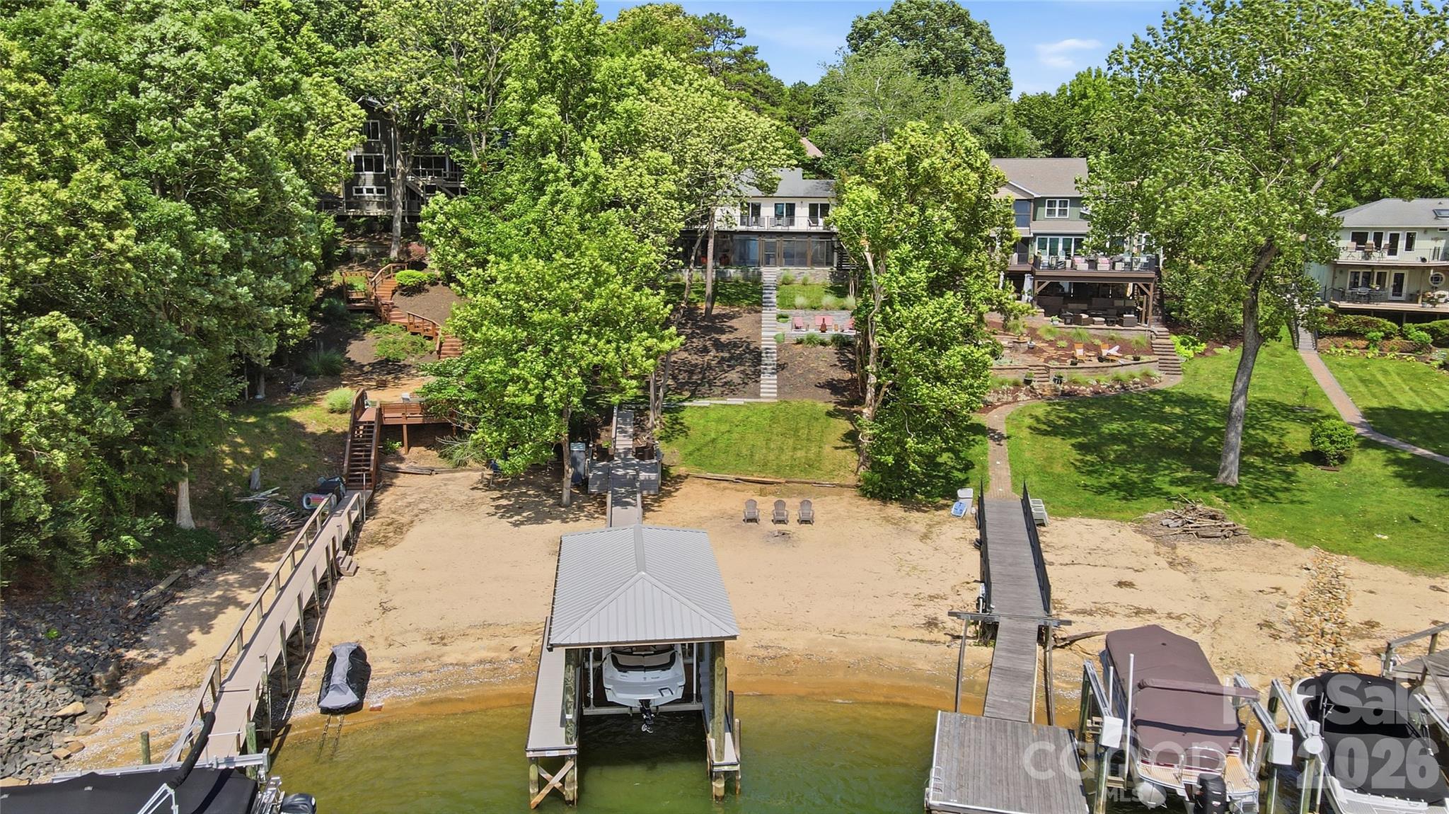 Some homes are places to live. This one is a place to land, to slow down, soak it in, and remember what summers are supposed to feel like.
Tucked into one of Tega Cay's most coveted waterfront locations, this beautifully updated home sits front and center on the main channel with wide open water views that greet you the moment you walk through the door. A sprawling open cove with a sandy beach gives you your own private retreat, and the sunsets here, framed perfectly from the deck and the water's edge, are the kind that become part of your daily rhythm.
This is where weekends start with morning coffee on the deck and end with bonfires and s'mores. Where summers are measured in fishing trips off the new dock and long afternoons in the cove. Where family and friends come, gather, and stay a while.
The home has been updated with new exterior siding, all new decking, and a brand new dock ready for everything lake life throws at it. Inside, a beautifully renovated kitchen and updated bathrooms deliver a clean modern flair while keeping the warmth of a true lake home intact. A new electric fireplace insert nestles into its natural stone surround - old and new blending seamlessly - and the fully enclosed sunroom lives like the outdoors in every season, with front-row water views year round.
Then there's the community wrapped around it all. Tega Cay is a one-of-a-kind peninsula city on Lake Wylie where the lifestyle is genuinely built around the water and the people who love it. Miles of walking and biking trails wind through the peninsula. Multiple community pools, tennis and pickleball courts, a disc golf course, a marina, boat ramps, and green spaces give residents an outdoor playground right outside their door. The golf course adds another layer to a community that has quietly become one of the most desirable addresses in the entire Charlotte metro. Neighbors know each other here. The Fourth of July feels like a small town celebration. It's the kind of place people move to and never want to leave - and this waterfront home that sit on the main channel will feel like the  crown jewel of it all.
All of this, zoned to the award-winning Fort Mill School District - consistently ranked among the best in South Carolina and recognized nationally for academic excellence - making this not just a dream lake home, but a genuinely smart place to put down roots.