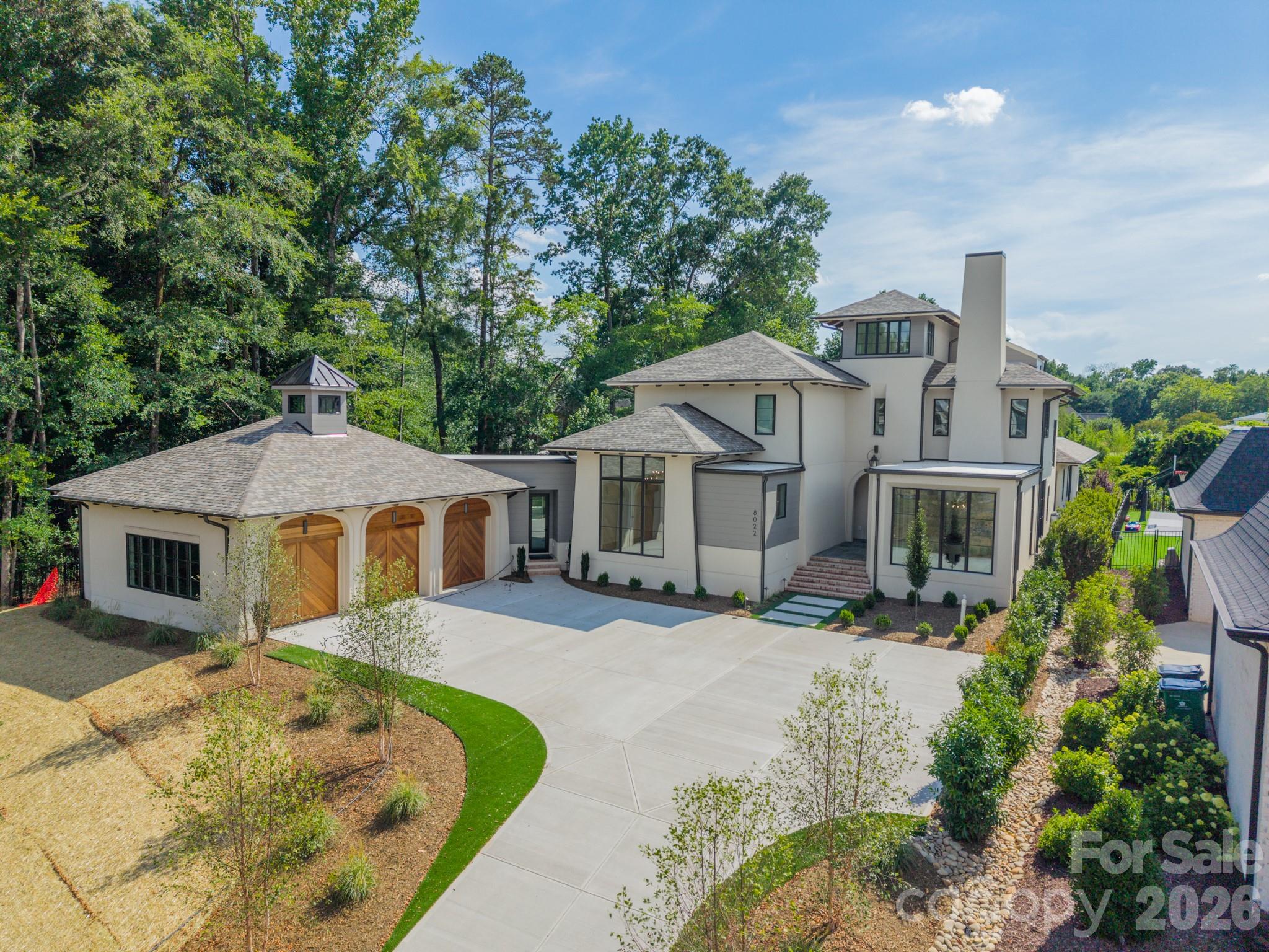 The wait is over—The Modern Manor is officially complete! Designed in collaboration with Mermans Architecture and Grandfather Homes, this stunning custom residence blends striking architecture with the kind of thoughtful spaces that make everyday living feel extraordinary. Located within the gated community of The Manors at Mattie Rose, this home offers a rare opportunity to enjoy new construction luxury in one of South Charlotte's most sought-after locations. Step outside and you'll quickly understand that this home was designed for entertaining. The expansive covered terrace, complete with a gas fireplace, overlooks a resort-style pool and spa that feels more like a private retreat than a backyard. Inside, the heart of the home is a chef-inspired kitchen featuring a large gathering island, walk-in pantry, and dedicated scullery with secondary appliances. Both the primary suite and a private guest suite are conveniently located on the main level, creating comfortable spaces for family and visitors. The upstairs private office provides a quiet place to work or create, while the bonus room offers endless possibilities for movie nights, a playroom, or whatever fits your lifestyle.
