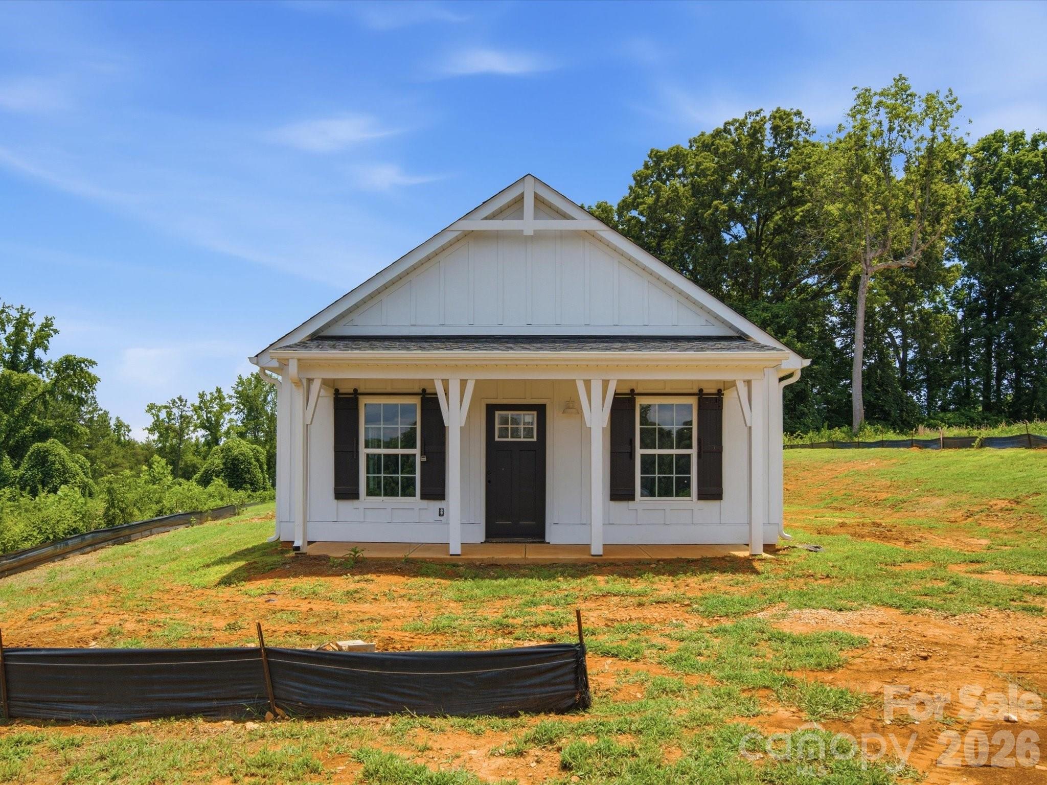 Welcome to this stunning new construction farmhouse style Craftsman nestled in a peaceful country setting in desirable Clover! Enjoy the perfect blend of quiet country living while being just minutes from the towns of Clover and York. Situated on a beautiful level lot in an established neighborhood with no HOA, this property offers plenty of room to spread out! Perfect for dogs, pets, or even a few animals! Inside, the open concept floor plan and neutral color palette create a warm, inviting space that’s ready for you to make your own. Luxury vinyl plank flooring, custom finishes, and abundant natural light flow throughout the home. The beautiful kitchen features shaker style cabinetry, quartz countertops, a shiplap backsplash, and ample workspace for everyday living and entertaining. The spacious primary suite offers a relaxing retreat with a walk in closet, double vanity, and walk in shower. Two additional bedrooms, a full bath, and a convenient laundry room complete this thoughtfully designed one level floor plan. Enjoy your morning coffee on the covered front porch or unwind on the covered back porch while overlooking the huge backyard, offering endless possibilities for outdoor living, gardening, play, or creating the perfect space for your furry friends. Experience the charm of farmhouse living in a peaceful country setting with the convenience of nearby shopping, dining, and award winning Clover schools. Welcome home to 1432 Blackbird Drive!