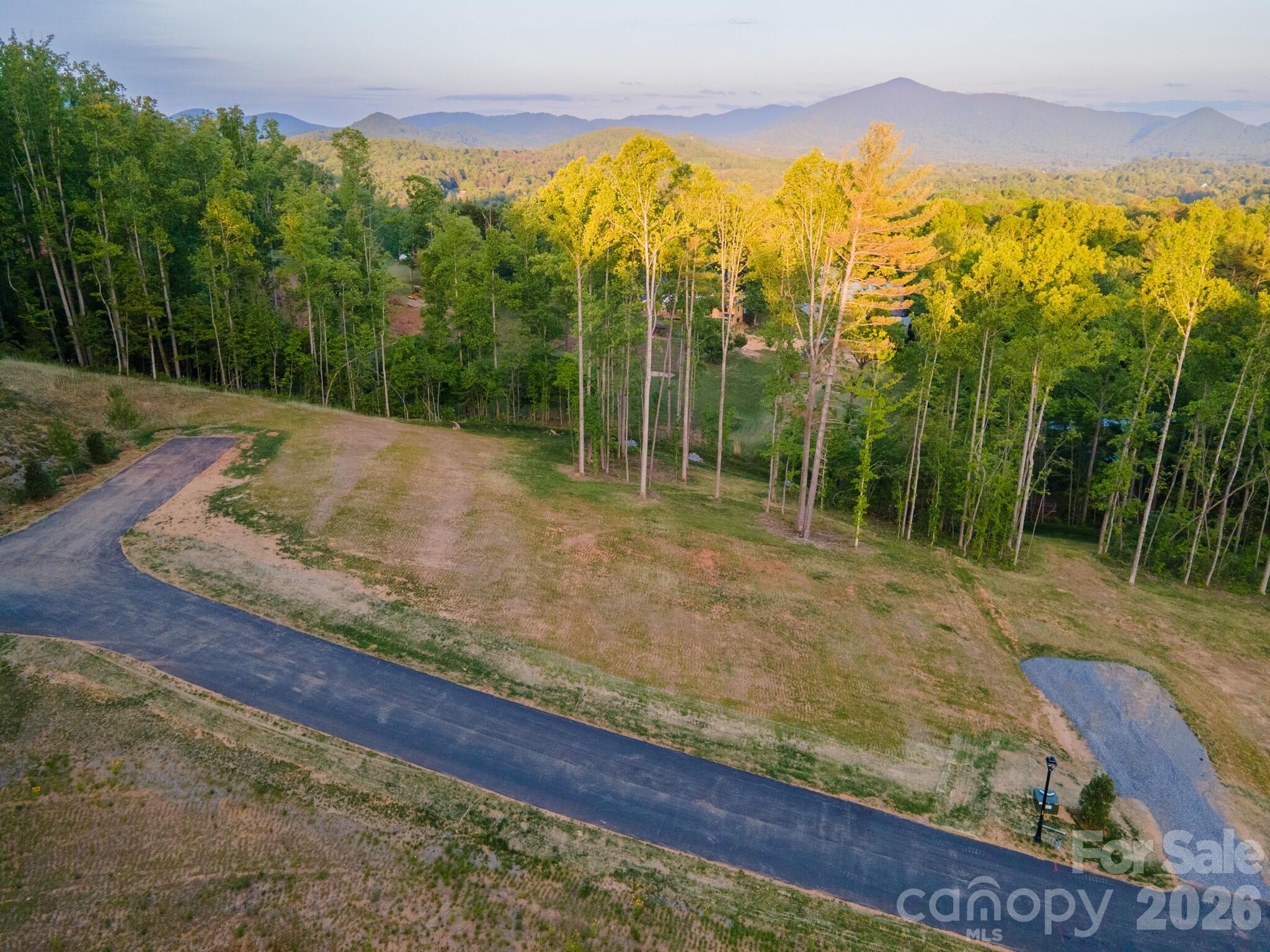 Homesite Seven at Harris Cove is a rare flat parcel of about 0.89 acres at the quiet terminus of the private road, accessed off the T-turnaround for added seclusion and minimal through-traffic. Long-range mountain views are enjoyed through the year, unobstructed by seasonal foliage, so the architecture can sit composed and low against the open horizon, subject to design. It is among the most easily buildable parcels in the community. Harris Cove is a private, gated, eight-lot community off Irvine Drive in Fairview, NC, near Asheville, with a restaurant, brewery, ice cream parlor, and library a short distance away. It includes a private road, gated entry, street lighting, underground Duke Energy power, and shared StormTech stormwater, with well and septic per lot.

Every home is reviewed by an Architectural Review Committee; Tykke Homes is the preferred builder, and other qualified builders are welcome.