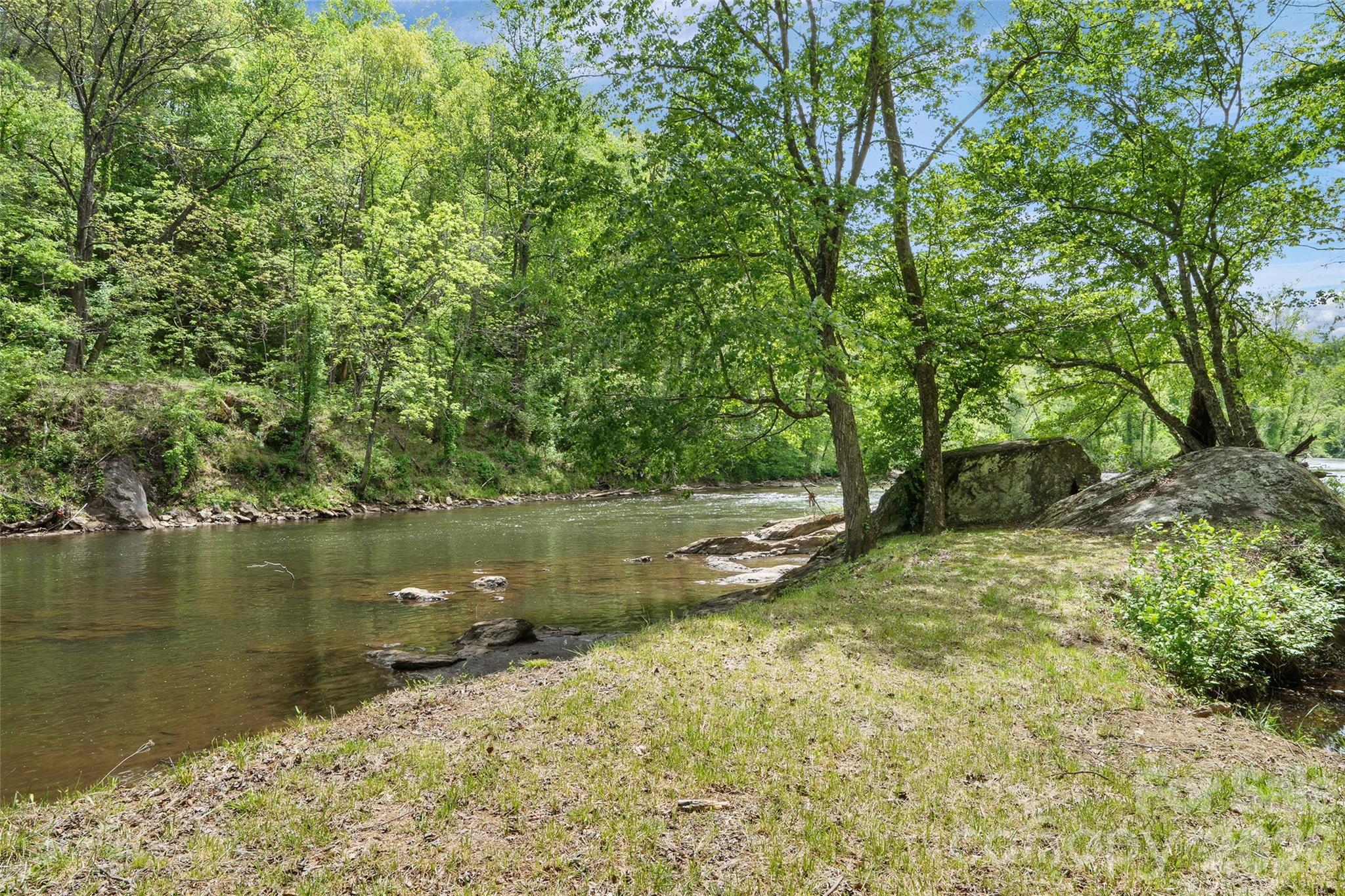 Rare opportunity to own over 8 acres of premier riverfront property along the stunning Tuckasegee River in Dillsboro—one of Western North Carolina’s most sought-after waterways for recreation and trout fishing. This exceptional parcel offers a beautiful combination of usable land, privacy, and breathtaking natural surroundings—ideal for your mountain getaway or full-time residence. Extensive improvements are already in place, saving you significant time and upfront cost. The property features a private well, septic system installed, gravel driveway, and a graded house pad positioned to capture expansive, year-round views of the river. A dedicated camper pad with electric and internet allows for immediate use, and a 2021 camper is available for purchase, giving you the option to enjoy the property while building. The Tuckasegee River is widely known for its delayed harvest and stocked trout waters, supporting healthy populations of rainbow, brown, and brook trout. Anglers will appreciate the mix of gentle, wadeable sections along with deeper runs and pools—making this stretch a true fly fisherman’s paradise with consistent, year-round opportunity. Beyond fishing, the river offers excellent tubing, kayaking, and paddle sports, with calm stretches perfect for relaxing floats and scenic enjoyment. Located just downriver from Dillsboro River Company, with the first whitewater visible from the property, this location adds an exciting dynamic for those who enjoy a bit more adventure while still maintaining easy, everyday usability. The property also offers the potential to establish your own private river access trail or launch point, enhancing both recreation and long-term value. For the adventurous buyer, this property delivers an unmatched outdoor lifestyle—spend your mornings casting into cool mountain waters, afternoons floating the river, and evenings enjoying the peace and privacy of your own 8+ acre retreat. With ample room for exploration, recreation, and future expansion, this is a rare chance to own a true Western North Carolina playground. Conveniently located just minutes from downtown Dillsboro and Sylva, you’ll enjoy the perfect balance of peaceful seclusion and easy access to shopping, dining, and local charm.
If you’ve been searching for a build-ready riverfront property with infrastructure already in place and exceptional recreational appeal, this is a standout opportunity you don’t want to miss.
