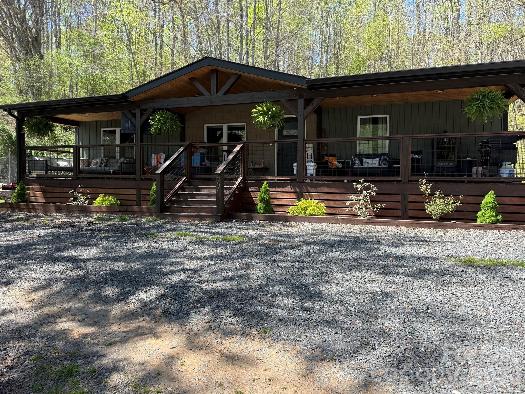 Updated 3BR/2BA doublewide on approximately 1 acre featuring a warm rustic-modern design with wood accents throughout, open living spaces, and thoughtful updates. The spacious kitchen offers an oversized island, updated cabinetry, stainless appliances, and plenty of room for gathering and entertaining. Primary suite features a beautifully renovated bath with soaking tub and separate shower. Bonus 264 sq ft addition provides flexible extra space perfect for a game room, office, den, or guest area. Covered front porch, usable yard, and detached outbuilding add to the appeal of this move-in ready property.