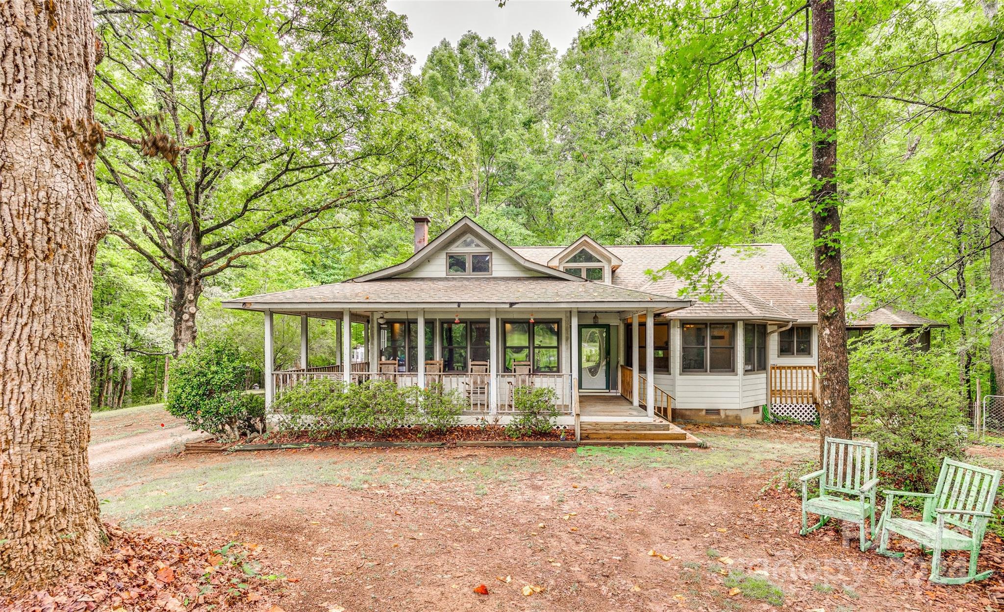 Nestled on over 13 acres, this stunning property offers a perfect blend of privacy and natural beauty, with lush woods and a flowing creek creating a serene backdrop.  With no restrictions and no HOA, this land presents endless possibilities, whether you're looking to build a few family homes or create a thriving farm or gardening haven. The existing 3-bedroom, 2-bath home exudes a warm and fuzzy feeling reminiscent of your grandma's house, inviting you to relax and unwind. The rocking chair front porch and wrap-around porch with a screened gazebo provide perfect spots to enjoy the peaceful setting and take in the beauty of nature. Property is being sold as is.