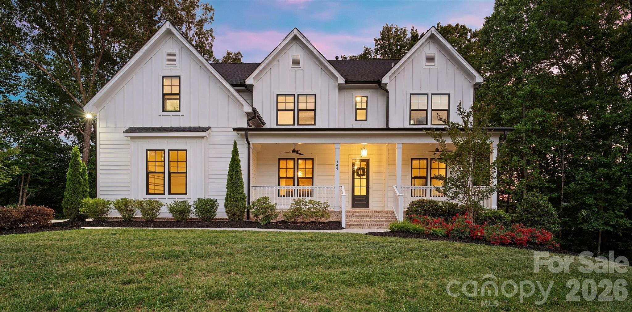 Tucked into the rolling topography of Anniston, one of Davidson’s most coveted communities, this custom modern farmhouse delivers high-end design with a warm, down-to-earth heart.

Perfectly positioned on a premium 1.3-acre lot, this home offers a rare degree of privacy. Because the property backs directly to mature woods and protected common area, you enjoy massive separation from neighbors on both sides, a buffer that simply cannot be replicated.

A classic rocking-chair front porch welcomes you into a light-filled floor plan that effortlessly balances everyday comfort with elevated finishes. Hardwood floors run throughout the main level living areas, grounding the open-concept layout in warmth and texture.

The gourmet kitchen is a true chef’s dream, featuring a bespoke range hood, gas cooktop, double ovens, an oversized island built for gathering, and an expansive layout that flows seamlessly into the main living areas. Tucked just off the kitchen, a true butler’s pantry provides the ultimate hidden workspace for meal prep and entertaining, the kind of detail that separates a good home from a great one.

The adjacent dining room boasts a deep coffered ceiling, adding architectural elegance to every dinner party. The living room anchors the heart of the home with a stunning gas fireplace and a massive picture window, giving you front-row seating to watch the foliage unveil itself in the surrounding woods each autumn.

The main level is exceptionally functional, featuring a private downstairs guest suite with a full bathroom and an attached flexible room perfectly sized for a home office, nursery, or playroom, ideal for multi-generational living or work-from-home households.

Upstairs, the luxury primary retreat lives as a private wing, complete with brand-new high-end carpet, a fully organized custom closet system, and a spa-like bathroom showcasing a free-standing soaking tub, a beautifully tiled walk-in shower, and double vanities.

Three additional secondary bedrooms reside on this level. Two boast striking cathedral ceilings, with one featuring a private en-suite bath and the remaining two sharing a smart Jack-and-Jill layout, the kind of thoughtful design that makes daily life with family genuinely easier.

A massive upstairs bonus room serves as the ultimate media or recreation hub, located just steps from an oversized laundry room packed with built-in cabinetry for seamless storage.

The rear of the property is built for relaxed outdoor living, centered around a large covered back deck overlooking your expansive, tree-lined backyard, the kind of space made for slow morning coffees, long dinners with friends, and unhurried evenings under the stars.

Complete with a 3-car garage, this home delivers a massive financial “wow factor”: because it sits just outside the Davidson town boundaries, buyers bypass city tax rates and pay only low Iredell County property taxes, a meaningful savings that compounds year after year.

Homes like this, on lots like this, in communities like this, do not come available often. Come walk the property, stand on the back deck, and feel why Anniston has become one of the most quietly sought-after addresses in the Lake Norman area. Your next chapter is waiting.