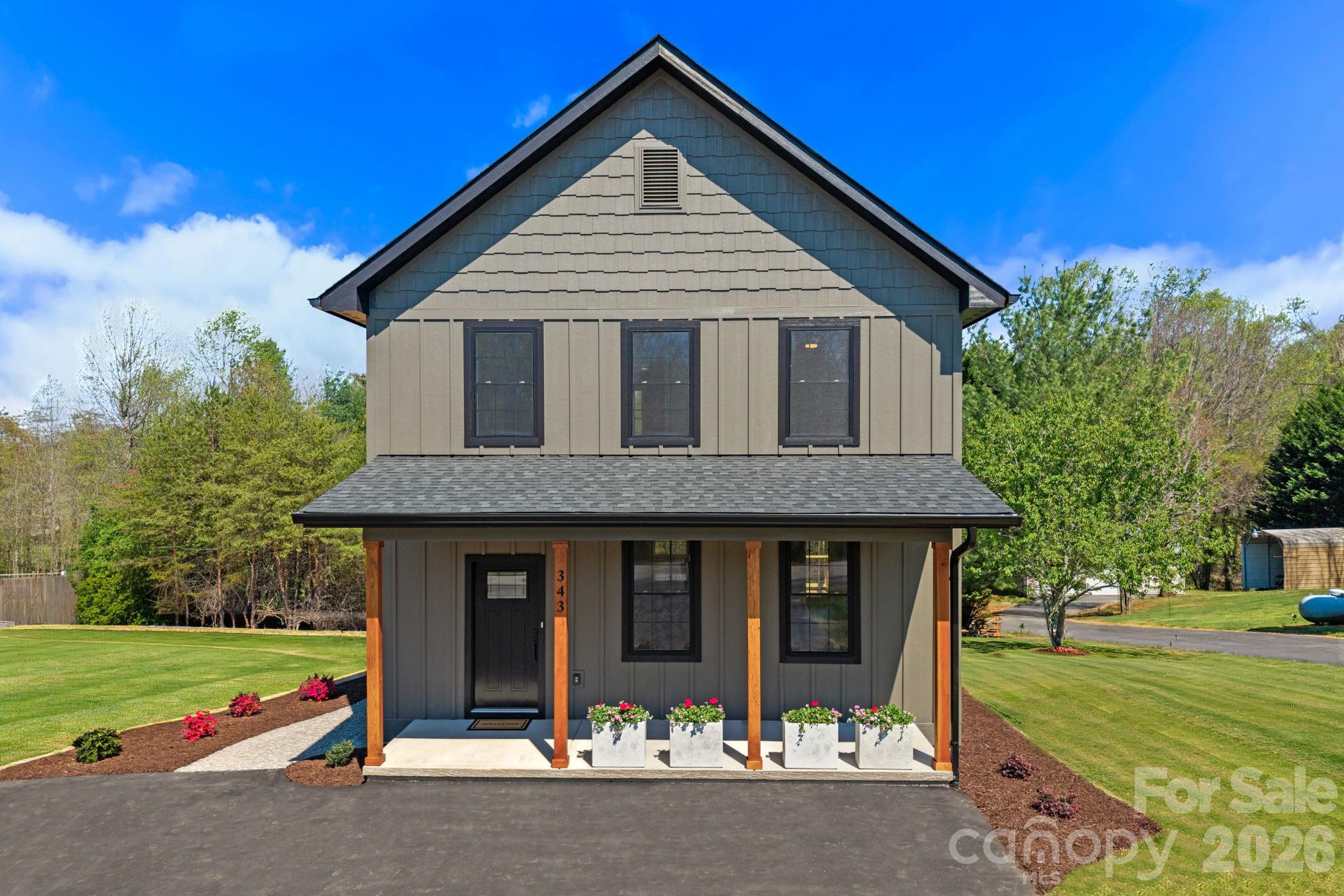 Stunning new construction just minutes from Downtown Asheville, showcasing cutting-edge modern finishes, clean architectural lines, and a design that feels both current and elevated.

The main level is centered around a vast open floor plan filled with natural light, creating a seamless connection between the living, dining, and kitchen spaces. Every detail has been thoughtfully selected, from the curated finishes to the intentional layout that enhances both style and livability.

The kitchen stands out with custom cabinetry, granite countertops, stainless steel appliances, and a spacious island designed for gathering and entertaining. The adjoining living area is anchored by custom built-ins, adding both character and function.

Attention to detail continues in the mudroom, where custom built-ins and a granite bench create a refined and practical drop zone just off the main living space.

Upstairs, the primary suite offers a well-designed retreat with a double vanity, modern fixtures, and a beautifully finished tiled shower. A spacious walk-in closet with custom shelving provides excellent storage and organization. Additional bedrooms are bright and versatile, offering flexibility for guests, work-from-home needs, or everyday living.

Outdoor spaces are equally inviting, with a covered front porch featuring warm wood accents and a back deck ideal for relaxing or entertaining.

Located less than 15 minutes from Downtown Asheville and the River Arts District, this home delivers a rare combination of modern design, thoughtful detail, and convenient access to everything Asheville has to offer. SELLER WILL INSTALL A 10X12 MATCHING SHED TO THE PROPERTY.
