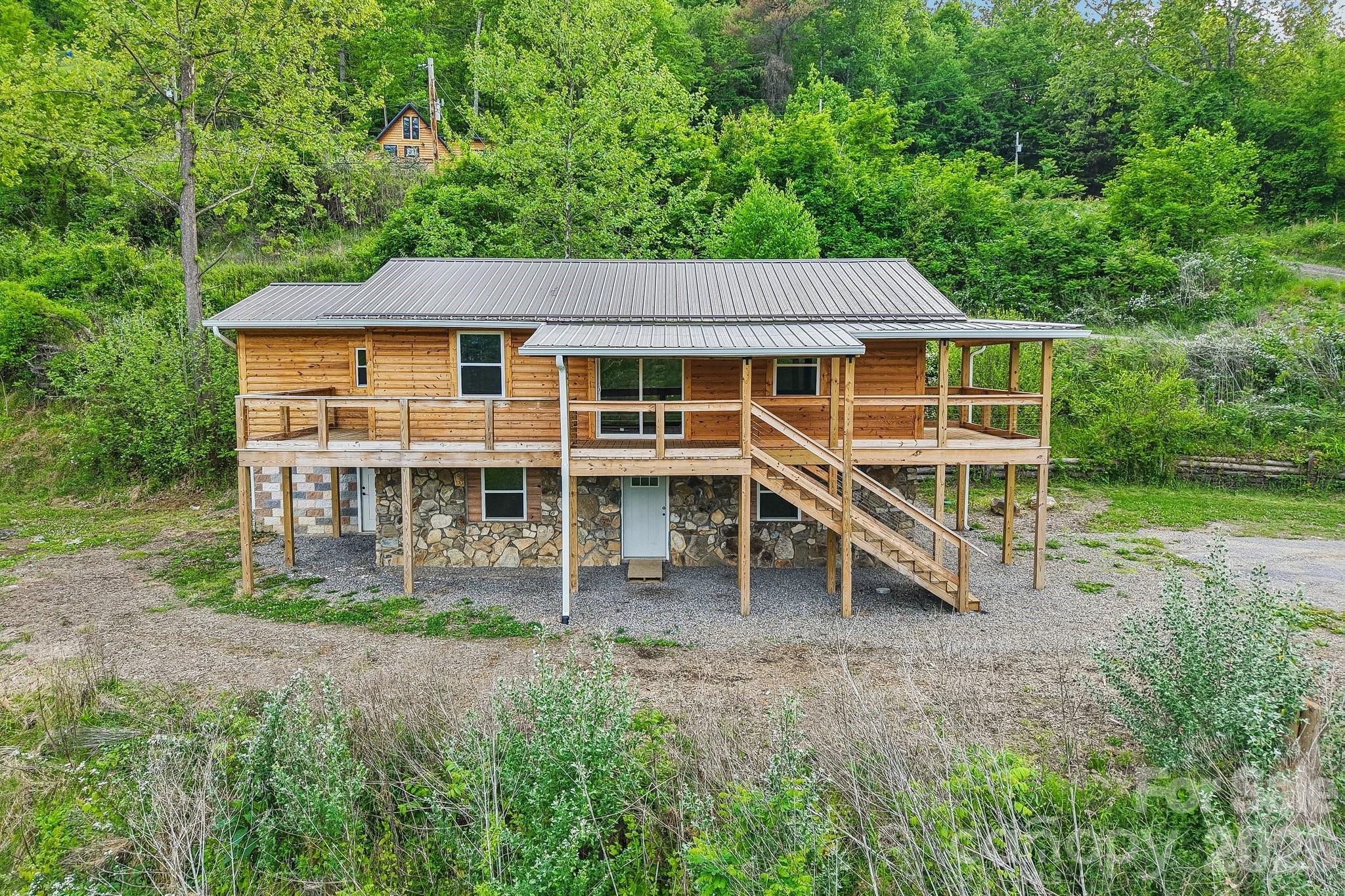 INVESTOR ALERT! Rare mountain income property and development opportunity on 10+ acres in Burnsville, just 45 minutes from Asheville. Situated in an Opportunity Zone, this versatile tract is the ultimate setup for a 1031 exchange, high-yield investment property, or affordable housing project. It is perfectly primed for a tiny home community, RV resort, or mobile home park.

The heavy lifting is taken care of with ready-to-build, de-risked infrastructure already on-site. This includes an established internal road system, power ready at each site, and 8 inspected septic systems with risers installed. Water is accessible from a robust spring house system piped directly to the units, supported by two 1,500-gallon storage tanks. The property features 4 turnkey, modern income-producing units: a stacked duplex (not side-by-side) with an upper 2BR/1BA unit (1,153 sq ft) and a lower 2BR/1BA unit (1,084 sq ft), both fully renovated in 2025; a brand-new 1BR/1BA A-Frame (515 sq ft) with cathedral ceilings; and a brand-new 1BR/1BA luxury tiny home (392 sq ft). All units are completely unrented since construction/renovation, offering a pristine, zero-wear canvas to maximize market rates.

Incredible expansion potential exists with the remaining infrastructure, which includes 3 additional 2BR septic systems, 2 additional 4BR septic systems, and 1 potential 2BR system. Scale up immediately with multiple tiny homes or larger multi-bedroom builds. Owner financing is an option with a strong offer! Enjoy authentic mountain living just minutes from the hub of Burnsville!