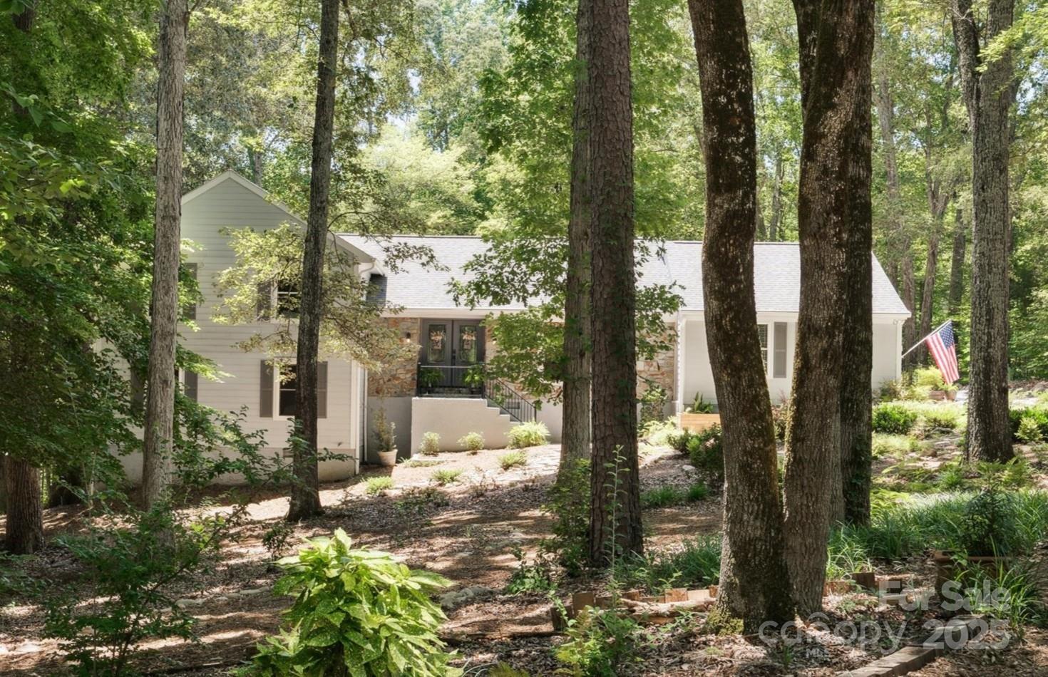 Rare find just outside the city limits of the Town of Fort Mill! Be prepared to be WOWED by this amazing home! Nestled amongst a canopy of mature hardwood trees & built in a park-like setting, this 5 bedroom, 3-1/2 bath, 2 car garage on almost 2 acres awaits your most descriminating buyers! Upon entering the double doored entry, you can feel the warmth & quality of this classic, modern, multi-leveled home. The open floorplan w/ large dining area, modern kitchen and family room with a vaulted ceiling & large windows basks in natural sunlight. The gas fireplace w/glass, flanked w/built-in bookshelves provides that modern vibe. Chefs kitchen w/ S/S appliances, gas cooktop, & abundance of counter space. Hardwood floors throughout the entire home (less tiled bathrooms), updated bathrooms, light fixtures, paint & more. The grounds of this amazing property makes you feel like you're in the mountains. The expansive, multi-tiered deck overlooks the impressive and peaceful rear yard.