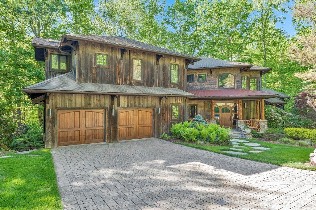 Canopy Falls House is a truly one-of-a-kind mountain retreat with a luxury treehouse vibe tucked into a private forest setting within the gated Yonahlossee community. A bold combination of mountain-modern architecture, artistic craftsmanship, and natural beauty creates an experience that is impossible to replicate at this price point. Enjoy the sights and sounds of a loud rushing creek and waterfall located on the property from multiple indoor and outdoor living spaces, including nearly 1,900 square feet of Ipe decking, a screened porch with stone fireplace, custom firepit area, stone walkways, and beautifully landscaped grounds. Offered fully furnished with few exceptions and with short-term rentals permitted, this home is perfectly suited as a luxury getaway, investment property, or full-time residence. The thoughtful floor plan provides sleeping areas, living space, and privacy on all three levels, making it ideal for hosting family and guests. The main level features vaulted ceilings, a dramatic wall of windows, stone fireplace, hardwood floors, antique barnwood accents, peeled log details, and numerous artistic touches throughout. The kitchen offers granite countertops, updated appliances, copper accents, bar seating, and a walk-in butler’s pantry. The main-level suite includes a walk-in closet, soaking tub, double vanity, cathedral ceilings, and direct access to the screened deck overlooking the waterfall. Upstairs, a striking wrought-iron bridge overlooks the great room and leads to an additional suite with private balcony, walk-in closet, and spacious bath, along with lofted office, fitness, or bonus space. The lower level is designed for entertaining with a second living area, stone fireplace, wet bar/kitchenette, pool table area, guest suite, bonus sleeping/flex space, and access to another expansive Ipe deck beside the creek. Additional features include fiber-optic internet, community sewer, radon mitigation system, security system, oversized two-car garage, and large workshop/storage space. Optional Yonahlossee club amenities include tennis, pickleball, pool, fitness center, and dining. Ideally located between Boone, Blowing Rock, and Banner Elk, and bordering Julian Price Memorial Park with direct hiking access nearby.