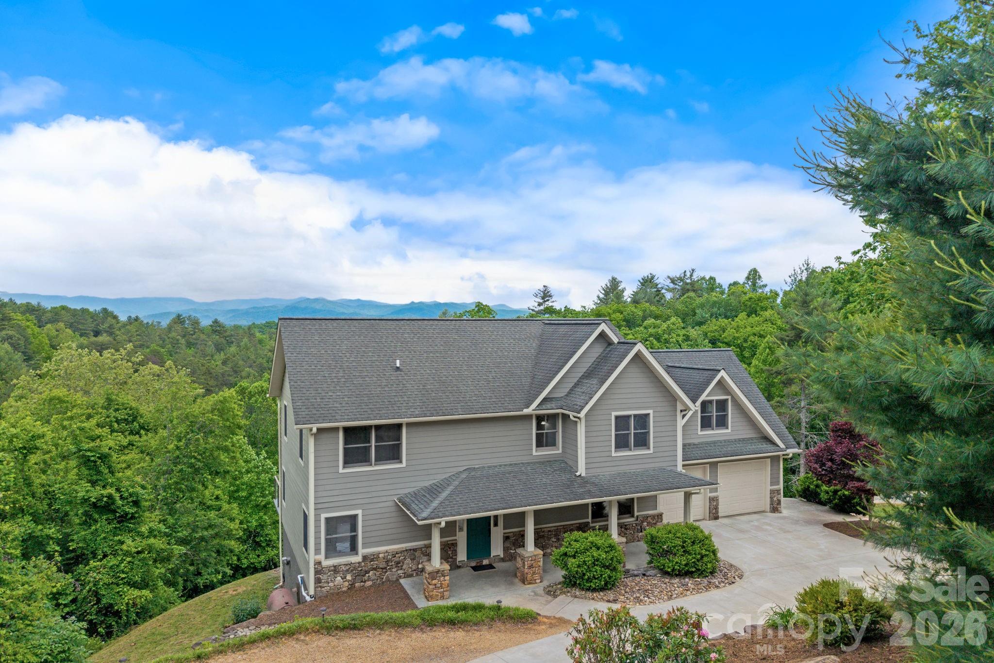 Sweeping long-range mountain views take center stage at this inviting home, where layered ridgelines stretch across the horizon and become part of the experience from both inside and out. Tucked into a peaceful, quiet setting that feels worlds away from everyday life, yet still offers convenient access to Marshall & Asheville. It's the best of both worlds. 
Thoughtfully curated landscaping and an expansive rear deck further enhance the setting, creating the perfect place to take in the views and natural beauty that surround the property. Inside, the home lives exceptionally large, offering over 2,500 square feet with plenty of room to spread out. A dramatic two-story great room with soaring ceilings and expansive windows fills the main living space with natural light while drawing in the surrounding mountain views. The main-level primary suite is accompanied by a spacious spa-like ensuite bath featuring a soaking tub, dual vanity, and tiled walk-in shower. Upstairs, multiple additional rooms, an office, and a large bonus space create exceptional flexibility for guests, hobbies, recreation, or remote work. The unfinished basement offers over 1,100 square feet of additional space, complete with a half bath and excellent future expansion potential. A spacious two-car garage on the main level, complemented by an additional lower-level garage, adds exceptional versatility for storage, recreational equipment, or workshop space. Offerings with this combination of views, space, privacy, and convenience rarely become available just outside of Asheville.