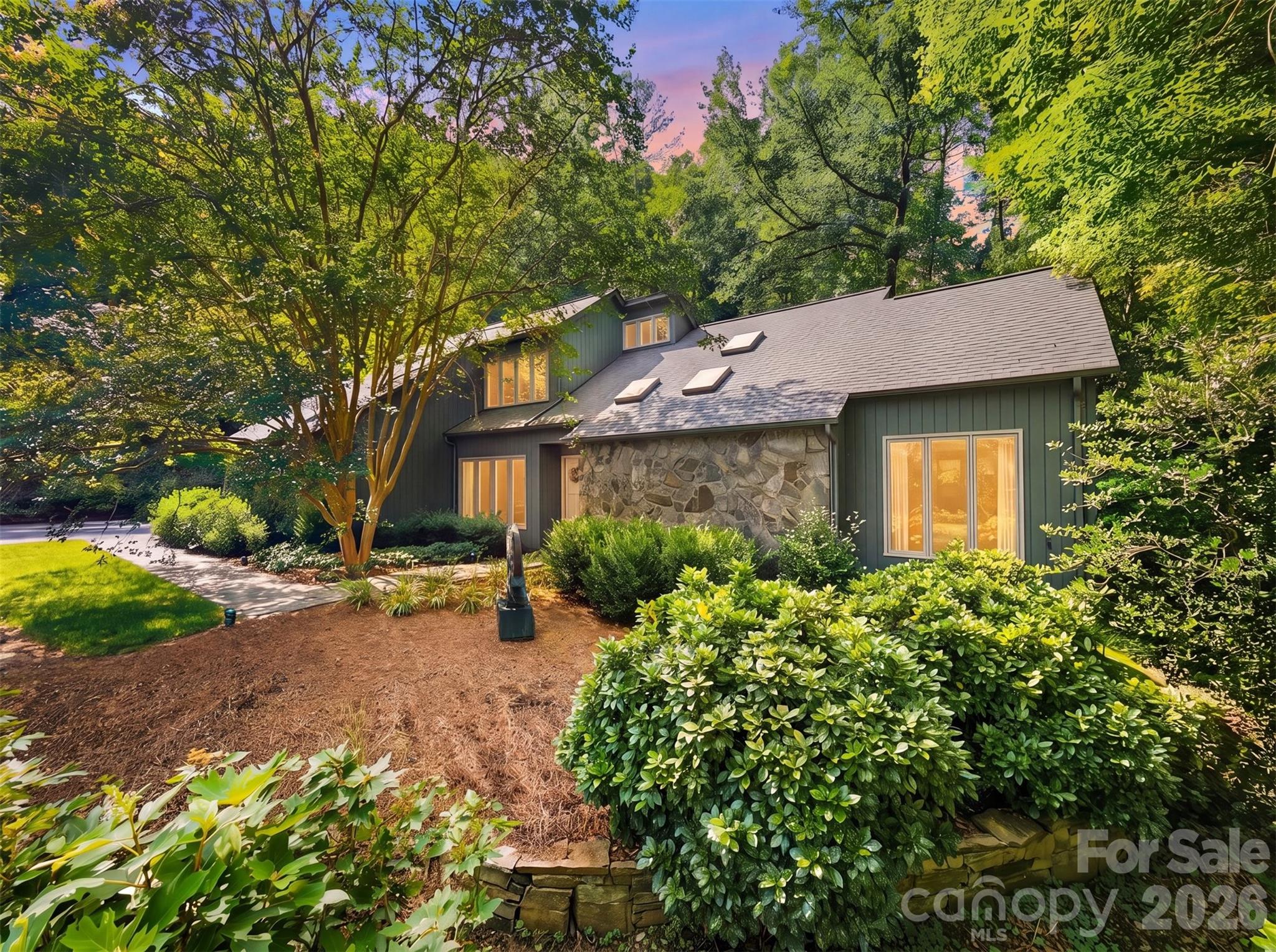 Nestled atop a private, tree-lined lot in the highly sought-after Stonecroft neighborhood, this timeless contemporary home blends distinctive architecture with comfortable everyday living, offering the character of classic contemporary design with spaces thoughtfully created for gathering, relaxing, and making memories. Step through the foyer and immediately appreciate the home’s open, intentional layout. The dining area flows seamlessly into a spacious living room anchored by a dramatic floor-to-ceiling stone fireplace with a built-in wood niche adding timeless character while creating a stunning focal point that invites conversation and connection. The kitchen is where this home truly comes to life. Beautifully updated with contemporary cabinetry, quartzite countertops, and an inviting breakfast area, designed for both everyday living and effortless entertaining. Just beyond, you’ll discover what may become your favorite space. The custom timber-frame screened porch is a true showpiece, showcasing exposed wood beams, exceptional craftsmanship, and peaceful views of the private backyard. Whether you’re enjoying your first cup of coffee, listening to a summer rain, or gathering with friends on a cool Carolina evening, this space was designed to be lived in. More than a porch, it’s a seamless extension of the home itself. The main-level primary suite offers a private retreat with its own en-suite bath and primary suite lounge area while a second bedroom and full bathroom on the main floor provide flexibility for guests, multigenerational living, or the convenience of one-level living. A spacious two-car garage with generous storage completes the main level.  Upstairs, you’ll find two additional bedrooms, a full bathroom, and a well-lit flex-room that’s perfect for a home office. The full basement is ready for your vision, already plumbed for a future bathroom and offering exceptional potential for expanded living space. The main area features a large stone fireplace, a workshop and space for organized storage.  A dedicated hobby room with an entire wall of built-in cabinetry with plenty of counter space provides the perfect setting for crafts, woodworking or hobbies. Step outside and discover a backyard designed for both relaxation and entertaining. Mature trees create a peaceful, shaded setting where a beautiful outdoor terrace serves as the centerpiece of a private gathering area. Book your showings, this one won't last!