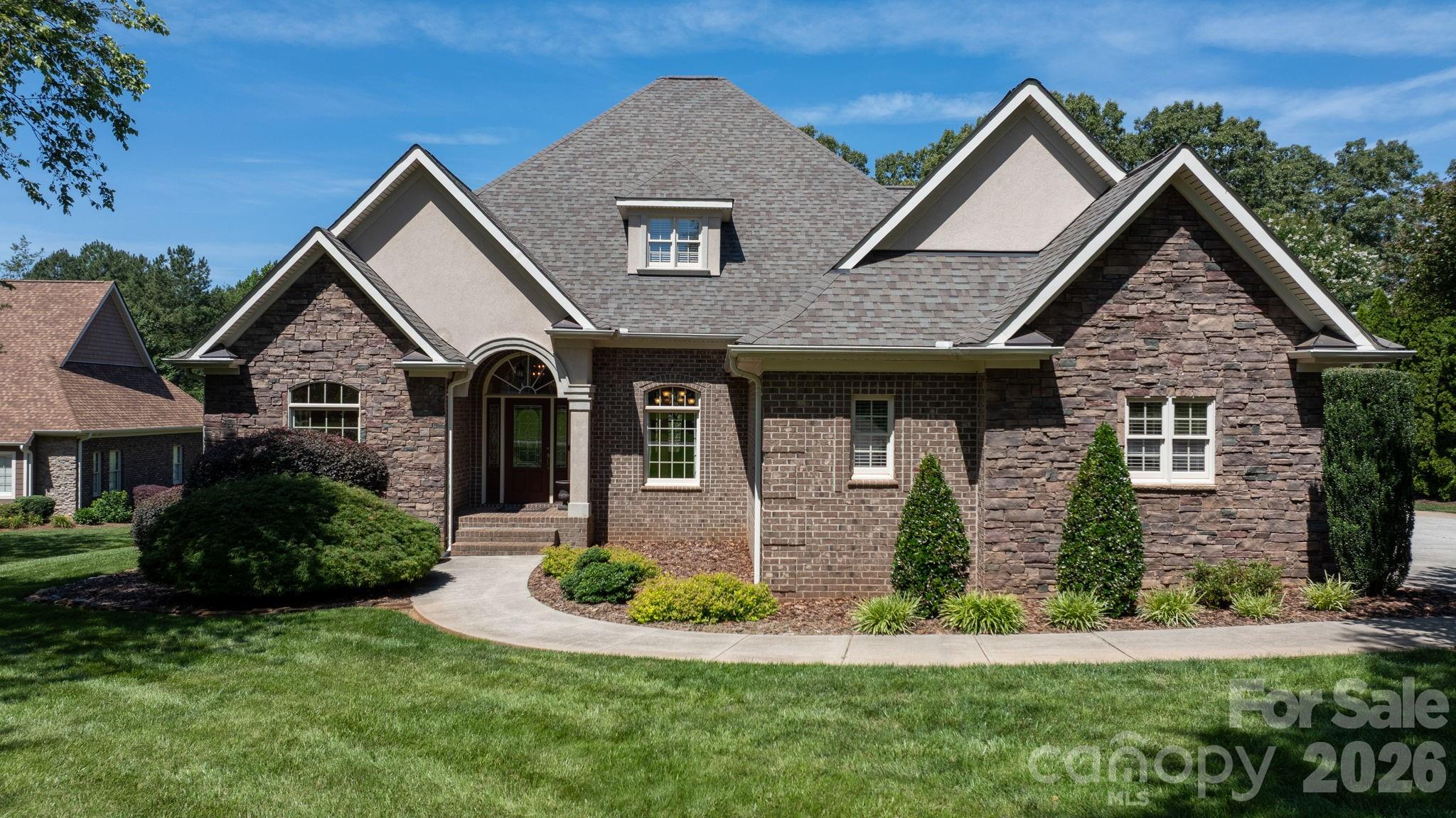 Discover this newly listed home in the highly sought-after Catawba Greens community! This beautifully crafted 4-bedroom, 3.5-bath custom home offers primarily one-level living with the added bonus of a finished upstairs bonus room.  From the moment you enter, you’ll appreciate the exceptional attention to detail, including heavy moldings, decorative columns, and a stunning cathedral ceiling. To the left of the foyer, you’ll find a private library and office space, and a formal dining room on the right.  The spacious great room serves as the heart of the home, featuring a dramatic floor-to-ceiling stone fireplace with gas logs. The oversized kitchen is perfect for entertaining and everyday living, complete with granite countertops, stainless steel appliances, a gas range, center island, eat-at bar, and breakfast area.  Designed with a split-bedroom floor plan for added privacy, the expansive primary suite includes private access to the covered back patio. The primary bath offers dual vanities, a separate soaking tub, a tiled walk-in shower, and an oversized custom walk-in closet with built-ins and a vanity area.  A second primary suite with a private full bath is also located on the main level, ideal for guests or multi-generational living. Bedrooms three and four each feature walk-in closets and share a convenient Jack-and-Jill bathroom.

Recent updates include: Walk in attic flooring extending attic storage space (2023), New roof with 40 year shingles and ice shield with gutter guards (2023), Irrigation repaired and added wifi controller (2023), New drop in gas range (2025), New tankless water heater with upgraded tank capacity (2026), septic tank pumped (2026).