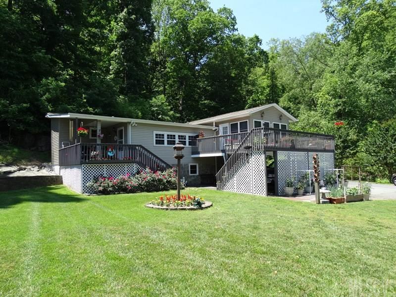 Calling all lake lovers! Mint condition 2BR/2BA home on LEVEL lake lot! Property includes attached carport parking for 3 cars plus a detached carport & storage building. Boat dock with seating plus covered boat slip. The house offers a covered porch deck & a large open deck. LR & DR with hdwd floors. Recently updated kitchen with Corian countertops, tile backsplash & new appliances. Walk-in pantry. MBR suite with access to sunroom with propane heater & window A/C. MBA with jetted tub, separate shower, laundry area & WIC. Security system, replacement windows & cellar type basement with exterior access.