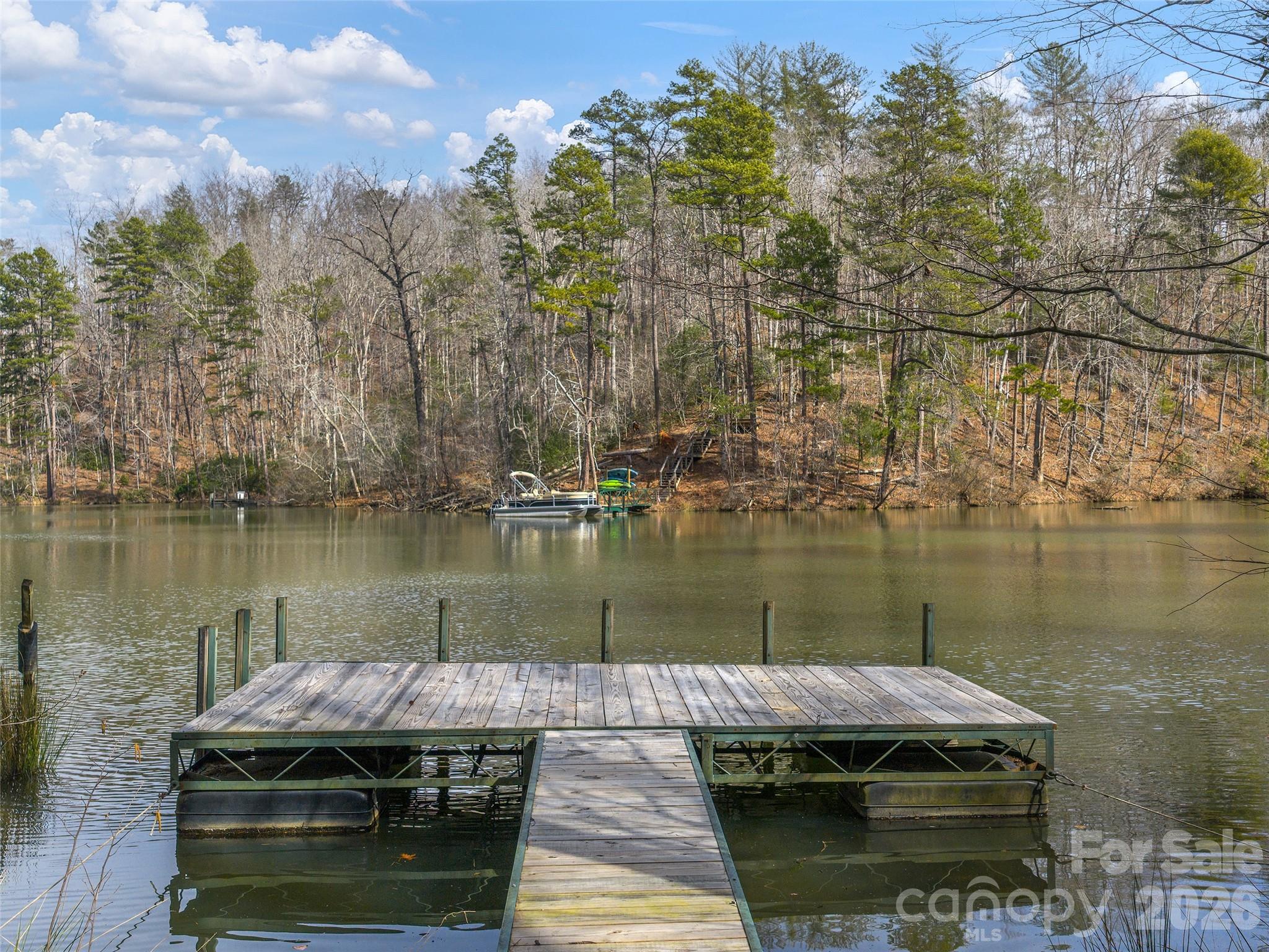 Exceptional lake front building lot on Lake Adger features over 135 feet of lake frontage. This property offers the opportunity to build your home close to the water and have easy access to your boat dock and waterfront just steps away from your backdoor. There is already a floating dock in place for your recreational use. The property is served by an existing shared well and has previously perked for a 3 bedroom septic (expires 6/25/2026 copy on file). Lake Adger has 14 miles of shoreline and 438 surface acres of water where you can enjoy boating, kayaking, fishing and swimming. The Lake Adger Community is a private planned community with 3250 +/- acres and includes 13 miles of private equestrian and hiking trails. Conveniently located to Asheville and Hendersonville, NC and Greenville and Spartanburg, SC. Come see this lot today!