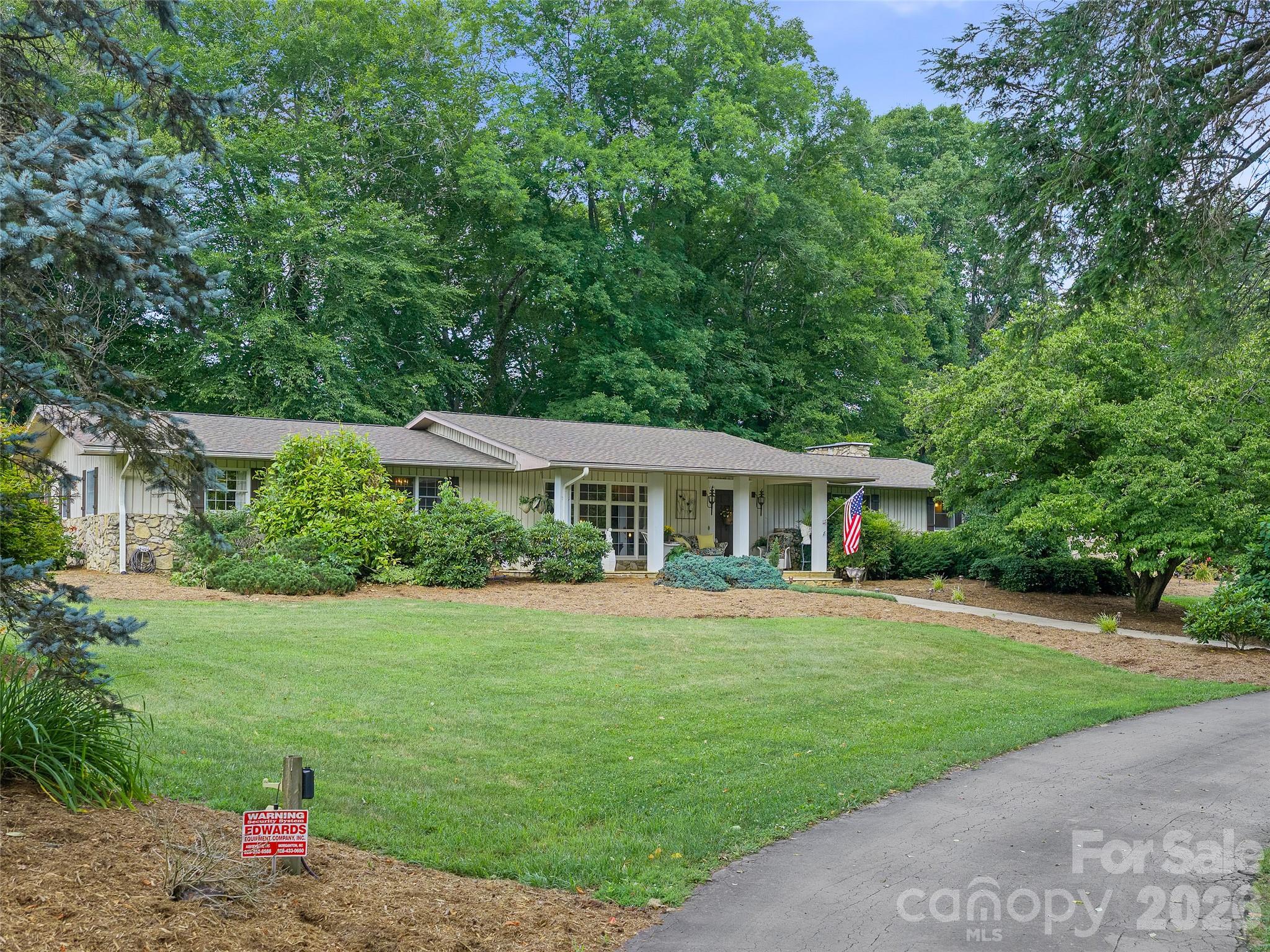 This property offers so many things increasingly hard to find.  If you have been searching for a home with substance, character and a true sense of place, this property is your destination.  Set in a peaceful farm setting of the mountains of WNC, this one level living home offers the kind of quality-over-quantity appeal that stands apart from newer, mass produced houses.  This home was built in an era when quality materials, thoughtful construction and lasting craftsmanship mattered. Surrounded by the beauty and rhythm of the countryside, this property reflects the deep roots of community and a way of life grounded in tradition, hard work, and pride of ownership. Enjoy the perfect blend of rustic elegance and modern comfort with upgrades such as dual zoned HVAC units. Crafted with care and attention to detail, the home features locally sourced, indigenous materials throughout. Highlights include rare hardwoods, such as oak, walnut, extinct wormy chestnut, native marble and natural appalachian stone from the surrounding region, adding character and timeless beauty to every room and a seamless flow to your outside spaces.  A home like this isn't about trends, it is about permanence, character and the kind of craftsmanship that lasts.  Immaculately maintained inside and out. The home's current design of 4BR/3 baths, also offers excellent potential for caretaker quarters, multigenerational living, or private guest accommodations.  With its spacious layout and full unfinished basement ready for expansion, the property lends itself well to creating a separate living area for a caretaker, extended family member, long term guest or even potential rental income, while still preserving privacy and functionality within the house.  If you are drawn to the quiet life, the charm of a long established area, sitting on your front porch taking in all the sights and sounds of nature in the sunshine or on the back patio in the shade listening to the babbling creek below, owning not just a house but a home with character and integrity, this property is for you.  Enjoy the best of both worlds with quick (less than 1 mile) access to I26, commuting and travel are easy and a short driving distance to Asheville Regional Airport, as well as other nearby destinations such as Johnson City, Burnsville, Boone, and Banner Elk.  Outdoor and art enthusiast will enjoy the proximity to the year around exhibits and events. Schedule your showing today to come and experience this great property for yourself.