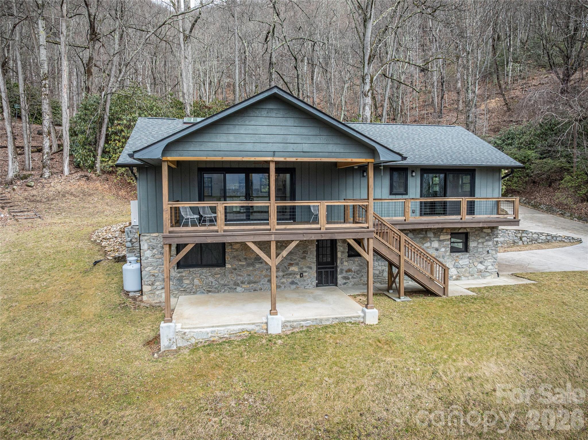 Completely renovated and move-in ready, this exceptional Friendly Acres home offers refined mountain living with high-end upgrades throughout. Designed for both comfort and style, the open floor plan is highlighted by wood-beamed ceilings and a striking new gas fireplace that anchors the main living space. The fully reimagined kitchen features custom cabinetry, updated lighting, and all-new appliances, while beautifully renovated bathrooms—including a primary suite with heated floors—provide a spa-like retreat. Fresh interior and exterior paint, new flooring, new windows, new PEX plumbing, updated recessed lighting and fixtures, and new ceiling fans reflect the quality and care poured into every detail.

This one-level home with a full basement offers flexibility and space, along with the rare convenience of two laundry rooms—one on the main level and one in the basement—with washers and dryers included. A two-car garage provides ample storage, and outdoor living is just as impressive with a covered deck, covered patio, and new deck ceiling—perfect for enjoying the peaceful mountain setting year-round.

Located just minutes from downtown Waynesville, Friendly Acres offers the ideal blend of privacy and accessibility. Enjoy easy access to local dining, shopping, and year-round events, along with nearby hiking trails, the Blue Ridge Parkway, and Lake Junaluska. This is mountain living at its finest—thoughtfully updated, beautifully finished, and ready to enjoy.