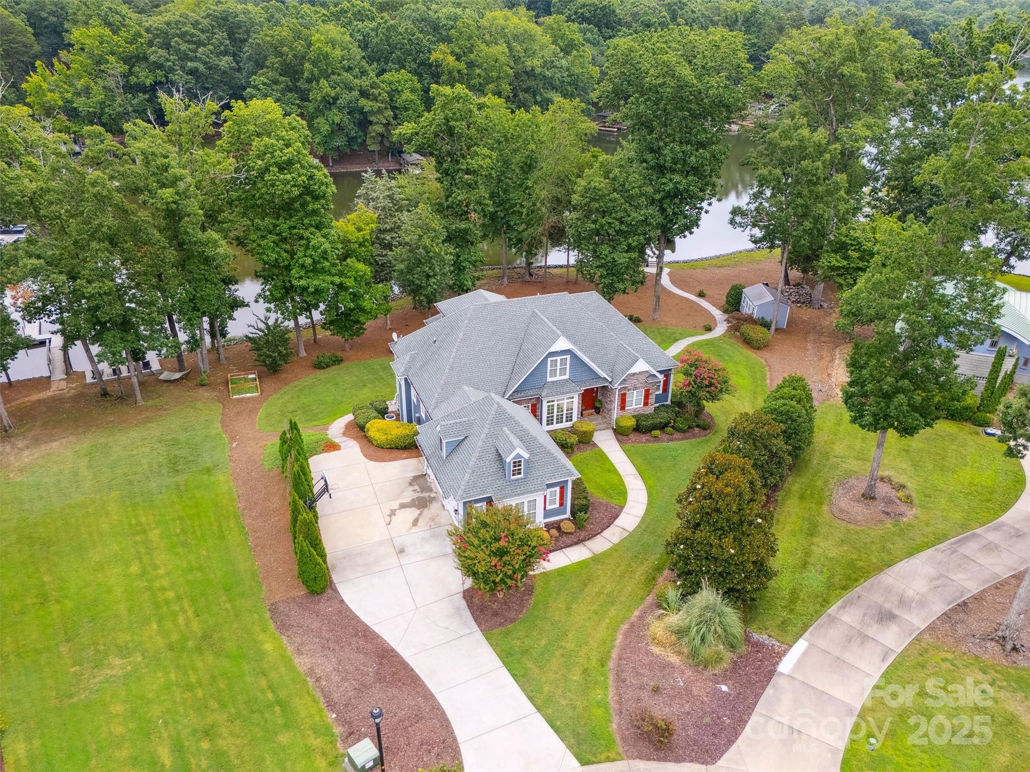 Multigenerational living/entertaining at its finest in the custom home on the lake! A short ride down Lake Wylie Road and situated at the end of a cul-de-sac, with amazing views of Lake Wylie, this flat lot boasts 330 ft of waterfront, with a covered boat lift for 2 boats and a jet ski pod. Enjoy those Carolina sunrises while sitting on your back, screened in porch off the kitchen sipping on your morning coffee, or dinner on the open patio just outside the living room. Walk out lower level is set up for entertaining or for use as a secondary living quarters, grab a drink at the bar and head down to the dock for an evening boat ride. Need storage? Tons of storage off the secondary kitchen as well as on the upper level. Lower level has 2 additional bedrooms and 2 full bathrooms to house your guests. Primary on main with 2 additional bedrooms, upper level has a bedroom, bathroom and office. Award winning Clover Schools, make this wonderful home with fabulous views yours today!