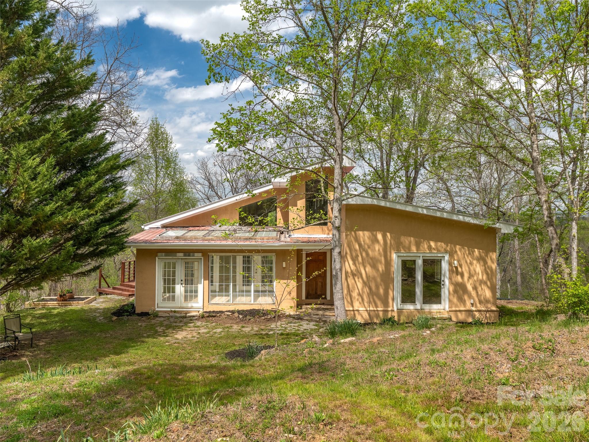 SELLERS ARE MOTIVATED TO FIND THIS PROPERTY ITS NEW OWNER! They have lived here, loved here, rented it and now need to send their son to college...
Welcome to 76 Raven Rock—a rare opportunity to own a private retreat on 3.74 acres perched along a dramatic cliffside, overlooking the French Broad River far below. Enjoy the peaceful sounds of the river right from your own front yard.
One of the most special parts of this property is the constant connection to nature. With regular visits from wildlife including owls, deer, wild turkeys, hummingbirds, pileated woodpeckers, and even great blue herons, right from the your deck. Just a short walk away, the cliffs offer a setting that feels like a private state park, perfect for exploring and taking in the beauty of the area
The home is a thoughtfully designed PASSIVE SOLAR home constructed with Rastra block, creating exceptional energy efficiency. RASTRA Insulated concrete forms are energy-efficient decreasing energy consumption by up to and above 50%. The property features terraced gardens and offers incredible potential for creating an outdoor living space, expansive patio, or even a second home for added income. This home could be a gardener's delight with the terraced back yard and the attached greenhouse/sunroom for your starters.
Inside, you’ll find soaring ceilings, original hardwood floors, tile floors, and a strategically placed JOTUL wood stove that enhances both comfort and charm. Cozy up by the fire with a good book in the reading nook and watch nature just outside your huge windows. Lots of natural lighting for the passive solar just invites nature inside. This 3-bedroom, 3-bathroom home also boasts a brand-new kitchen and freshly painted interior, making it move-in ready. 2 large, main level bedrooms, each complete with ensuite baths.
Another priceless benefit is the shared trails throughout the neighborhood.  Whether you're seeking a peaceful homestead or a lucrative short-term rental, this property delivers. This home has been a successful vacation rental as a super host.
Despite the sense of seclusion, the location is incredibly convenient. We’re just 10 minutes from downtown Marshall with Zuma Coffee & Provisions, MAD Co Brew House, Zadie's for food and music, and many more) and a short drive to Asheville, with easy access to the Ivy River for trout fishing and swimming holes, as well as nearby Hot Springs and the Appalachian Trail. It’s rare to feel so tucked away while still being close to everything.
(Check out our video of the home and downtown Marshall: https://youtu.be/44LenZY_Gf0)