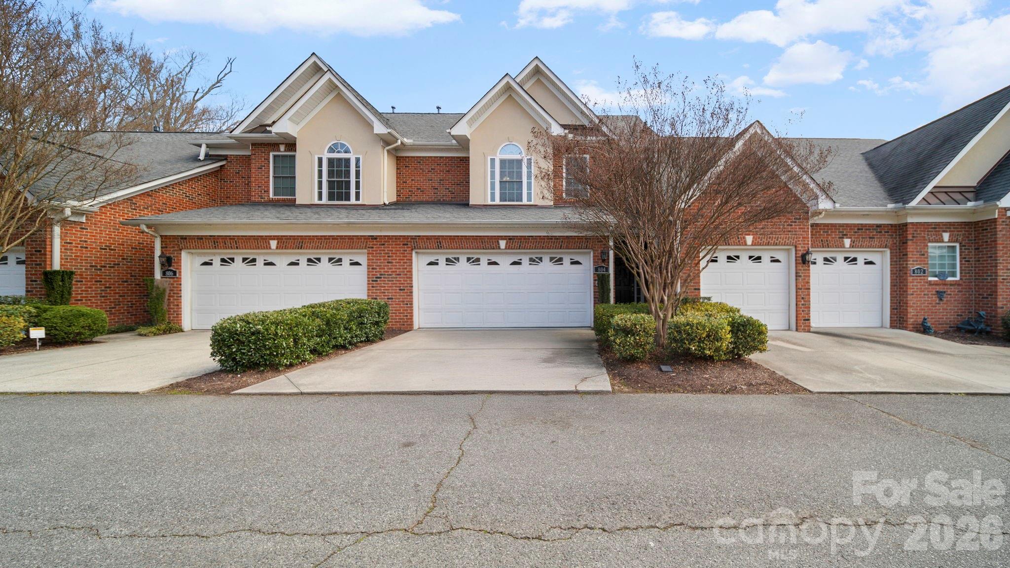 Welcome home to a private, gated brick townhome community known for its beautiful setting and neighborhood pond. Inside, enjoy hardwood floors on the main level and bright, airy 9-foot ceilings throughout. The kitchen is thoughtfully designed with granite countertops, 42" maple cabinetry, a spacious storage island, and a walk-in pantry—perfect for everyday living and easy entertaining. The breakfast area opens to a charming, private courtyard, creating a cozy spot for morning coffee or evening relaxation. A formal dining room framed by architectural columns adds an elegant touch for hosting friends and family.  The great room is warm and inviting, highlighted by a charming corner gas fireplace—perfect for cozy nights in.  Upstairs lead into a generously sized primary suite featuring a tray ceiling, a walk-in closet, and an ensuite garden bath with a double vanity. Two spacious, secondary bedrooms are conveniently located near the laundry area. The washer and dryer will convey with acceptable offer. A two-car garage completes the home.  As a resident, you’ll also enjoy outstanding community amenities, including a clubhouse, pool, tennis and pickleball courts, basketball, a picnic pavilion, playground, and two launch docks for kayaking or paddle-boarding. This is low-maintenance living with resort-style perks—don’t miss it!