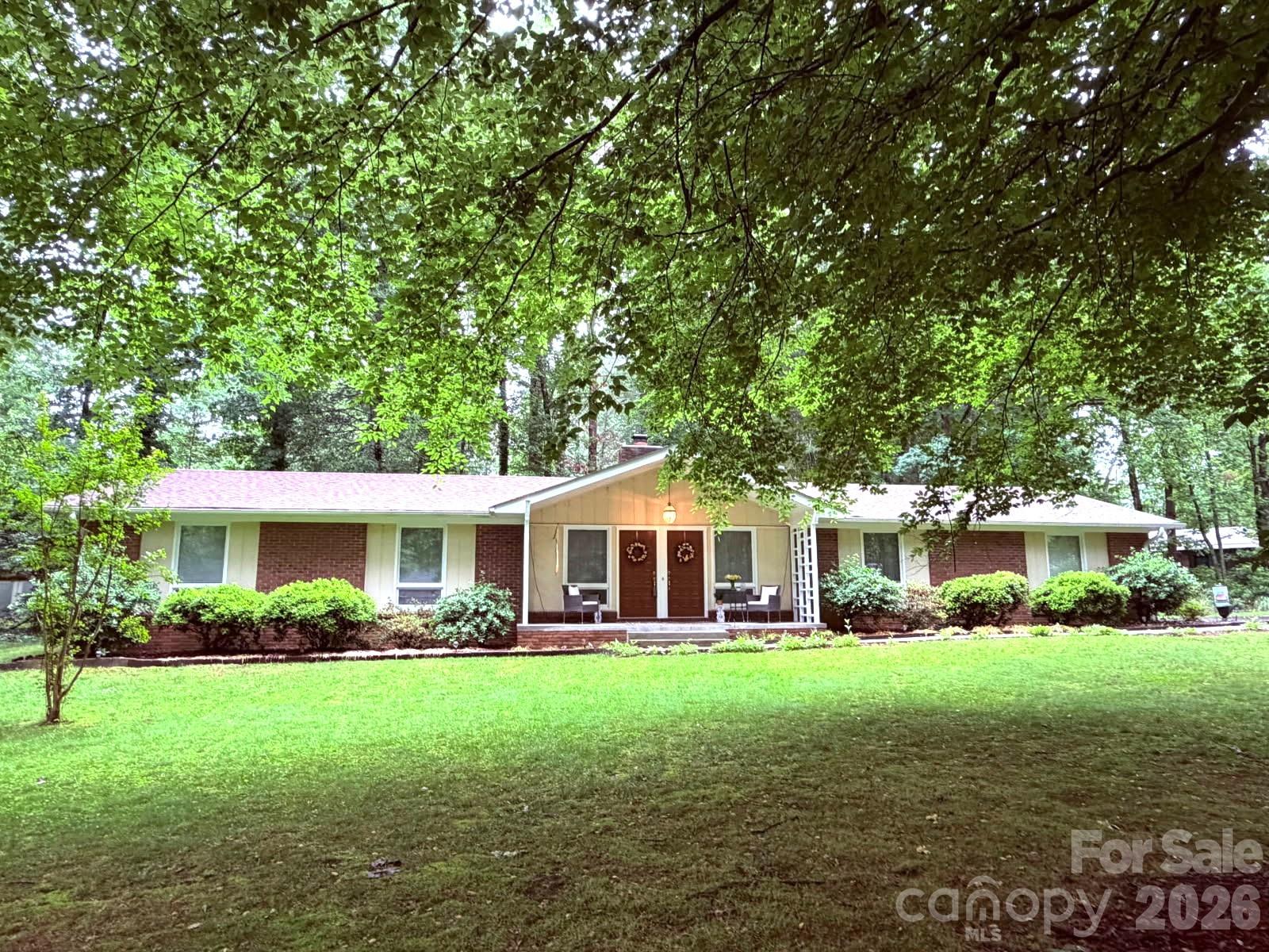 Beautiful brick one level home that has been very well maintained and located within walking distance to the Etowah Valley Golf Course and the Etowah area. Conveniently located between Hendersonville and Pisgah National Forest in Brevard. Etowah has most of the conveniences with a library, gas stations, Ingles grocery, Etowah Grade School, eateries, Dental Office, etc. The new Ecusta biking Trail will be in Etowah soon. Upgrades such as a new roof in 2023, deck, flooring, some fixtures.  Previous screened porch was turned into a charming 4 season sunroom with French doors and access to deck. Privacy in the backyard. Both bedrooms can be primary bedrooms, each with ensuite bathrooms. There is an additional office or multi-functional room.  Living room has a masonry wood burning fireplace and is open to kitchen  Lot is mostly flat and surrounded by wooded buffers for privacy. 
Some items can be furnished with the home --see attached upgrade list.