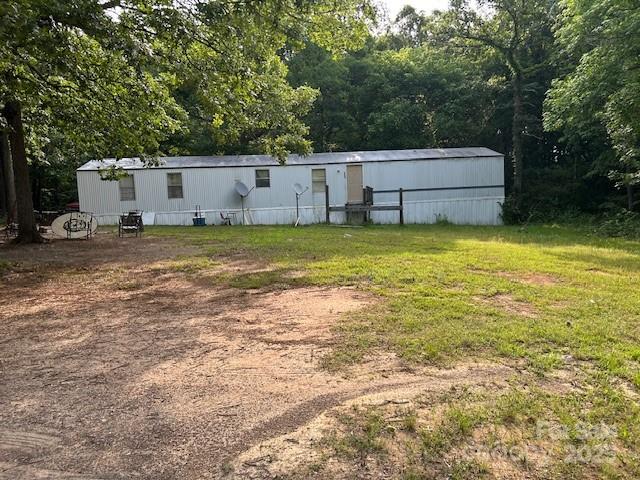 Quiet country location that features a 1+ acre lot and a singlewide mobile home. Mobile home has vinyl skirting and the interior is in need of repair. The property is being sold "as is."  Flooring (plywood) has been replaced in some area but in some areas be careful where you walk. Needs kitchen cabinets and bathroom vanities. One area in primary bath has roof lead in the ceiling. Hall bathtub has a crack in the bottom. This is a great fixer upper to live in or great for rental property. Mobile home has   heat pump that appears to be 5 years old according to the serial #.