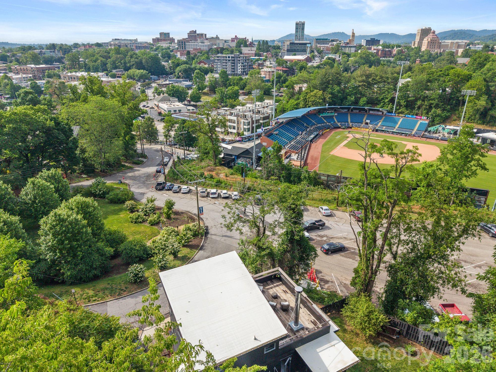 Own the only home in Asheville where you can watch professional baseball from your rooftop.
The Stadium House is a one of a kind modern residence where sophisticated design meets the energy of downtown Asheville. Overlooking Home Trust Park and Memorial Stadium, this impressive home offers a front-row seat to downtown Asheville. All from the comfort of your own property. Designed for both entertaining & everyday living, the home seamlessly blends indoor and outdoor spaces. Expansive walls of glass open to create an effortless connection between the chef's kitchen, outdoor living areas, and the surrounding mountain landscape. Host unforgettable gatherings on the main level, enjoy cocktails on the rooftop terrace as the sun sets over the stadium, or watch the game with friends from one of Asheville's most unique vantage points.
Located in Asheville's vibrant South Slope district for morning coffee, breweries, restaurants, and live music. Explore nearby trails, then return home to relax in the private outdoor shower before an evening out or a backyard cookout.Forget game-day traffic, parking hassles, and long commutes. Here entertainment, recreation, and downtown conveniences are woven into everyday life.
Distinctive, sophisticated, and impossible to replicate, The Stadium House is more than a home; it's an experience. A property that turns heads, sparks conversations, and creates a lifestyle your guests will never forget.