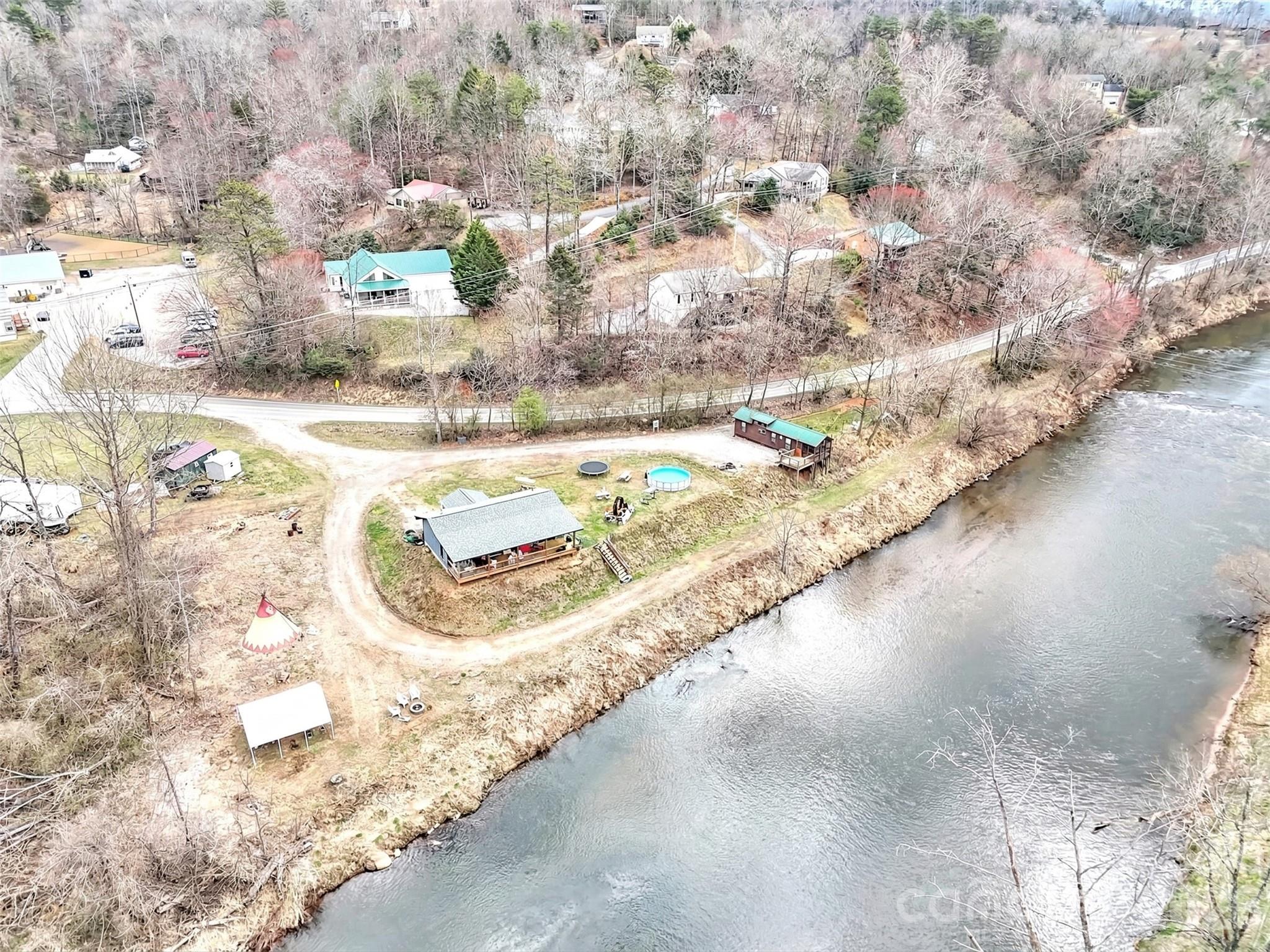 IMPROVED PRICE!   Dreaming of a mountain cabin on the water with plenty of room for a garden and room for a few rental units for extra money?  Want convenience to shopping, restaurants, schools and paved road access?   How about all of that and water, sewer, state maintained roads?  This is your opportunity!

Exceptional river frontage property offering in the mountains of western North Carolina!  This level 1.67 acre parcel with a cabin overlooking the river features 400 feet of frontage on the beautiful Tuckaseegee River, popularly referred to as "The Tuck".   Featured as a primary river for rainbow trout dry fly fishing, the Tuck is a year round outdoor recreation destination.  

Ideally positioned in Dillsboro area on North River Road (NCSR 1359) and just off US23/441, the primary north/south roading leading from Atlanta to Cherokee, the Great Smoky Mountains National Park and the Asheville area.  Dillsboro is the intersection of 23/441 and US 74, the Great Smoky Mountains Expressway.  The property's location  combines easy accessibility with privacy in a scenic setting along the river but features water and sewer served by the Tuckaseigee Water and Sewer with four (4) taps in place.

The parcel's flat topography, expansive river frontage and generous road frontage creates a compelling canvas for a boutique lodge, riverfront nursery, curated short-term rental concept or private estate.  The choices are unlimited.  While the property adjoins both of the towns of Dillsboro and Sylva, there is no zoning, allowing a broad range of residential options and affordability with no municipal taxes!  

Present uses of the property include a park model rental which has produced a substantial income in a modified short term rental (3 months and longer).  The owners have a two bedroom, two bath cabin overlooking the river and features a covered porch with hot tub overlooking the river.  The river frontage area has  been terraced down to the river and is included in the flood plain but the great majority of the property is high enough not to be in the food plain.  Hurricane Helene's heavy rains brought the water level up and into the terraced areas but did not encroach onto the level parts of the parcel!

Opportunies offering this combination of infrastructure, road and river frontage, location and flexibility along the Tuckaseegee River are rare and this presents both a lifestyle asset and a compelling long-term investment.
