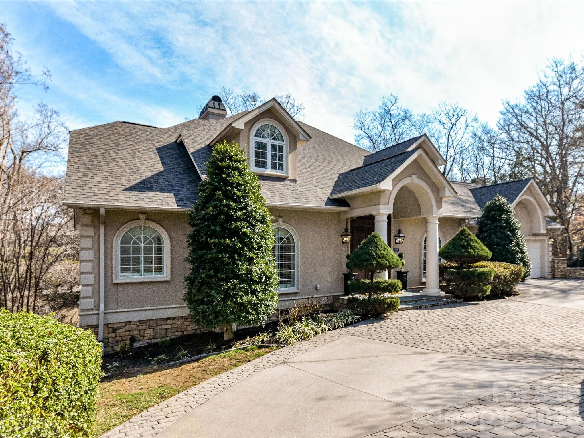 Fall in love with this exquisite custom built Executive Estate, privately nestled on approximately two acres & surrounded by the beauty of nature. Step inside and be instantly captivated by the breathtaking soaring 15-foot great room, where a stunning fireplace, flanked by custom built-ins, serves as the focal point, and walls of windows flood the space with natural light while framing peaceful views of the trees beyond. Step out onto the expansive upper deck to breathe in the fresh air and take in the serene setting. With 6,000 square feet of living space, across three thoughtfully designed levels, this home offers exceptional space for both everyday living and elegant entertaining. The sophisticated dining room sets the stage for memorable holiday gatherings, while the designer chef’s kitchen is truly the heart of the home, featuring a dramatic waterfall island, updated quartz countertops, gas cooktop, a peninsula with seating for four, and a charming eat-in area overlooking the picturesque backyard.  Start your mornings with coffee on the deck as you listen to the tranquil sounds of the nearby stream. The main-level primary suite is a private retreat, complete with heated floors, dual walk-in closets, a soaking tub, and a separate walk-in shower. Upstairs, two generously sized bedrooms each offer their own en-suite baths. The lower level is designed for relaxation and versatility. Unwind by the fireplace in the family room, curl up with a book on the expansive lower deck, or enjoy the additional two bedrooms with walkout access to the deck, plus a dedicated workout room. These rooms also provide flexibility for an additional home office or hobby space. Ideally located in the heart of Hickory, just minutes from downtown shops, restaurants, and Lake Hickory, this extraordinary property offers luxury, privacy, and convenience, all in one remarkable home.  Hurry, this gem won’t last long!