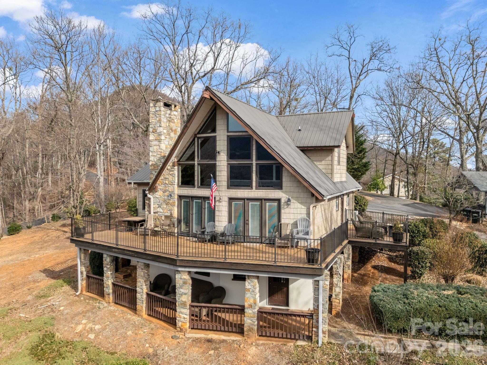 BIG VIEWS from this recently updated three-bedroom, two full bath home sitting high atop Youngs Mountain in Rumbling Bald on Lake Lure, available fully furnished and 100% turnkey with the right offer. A short drive down to all the resort amenities, including 24-hour security, lake access, private beach, indoor/outdoor pools, pickleball, tennis, two 18-hole championship golf courses, fitness center, spa, restaurants & bars and much, much more. Open concept living on the main level with a large kitchen island, breakfast bar, quartz countertops, SS appliances, dining area and a cathedral ceiling great room boasting a stunning floor-to-ceiling stone gas-log fireplace. Overlook unobstructed views of the Rumbling Bald rock face, as well as winter lake views from the wraparound rear deck. The upper level offers a sleeping loft open to the great room, a large bedroom, and a full bath. The main level has 2 other bedrooms, a full bath and laundry room. Downstairs you’ll find a family/Rec game room with a spacious utility/storage area. Walkout doors from the basement open to a covered sitting area and stone pathway leading to the stone patio with fire pit. On the side of the house is an awning covered deck with a grilling area off the laundry room and kitchen. Low maintenance cedar shake vinyl siding and metal roof. Full house generator and in ground propane tank. Excellent rental history with over 100 5-star reviews as a Short-Term Vacation Rental (STVR).