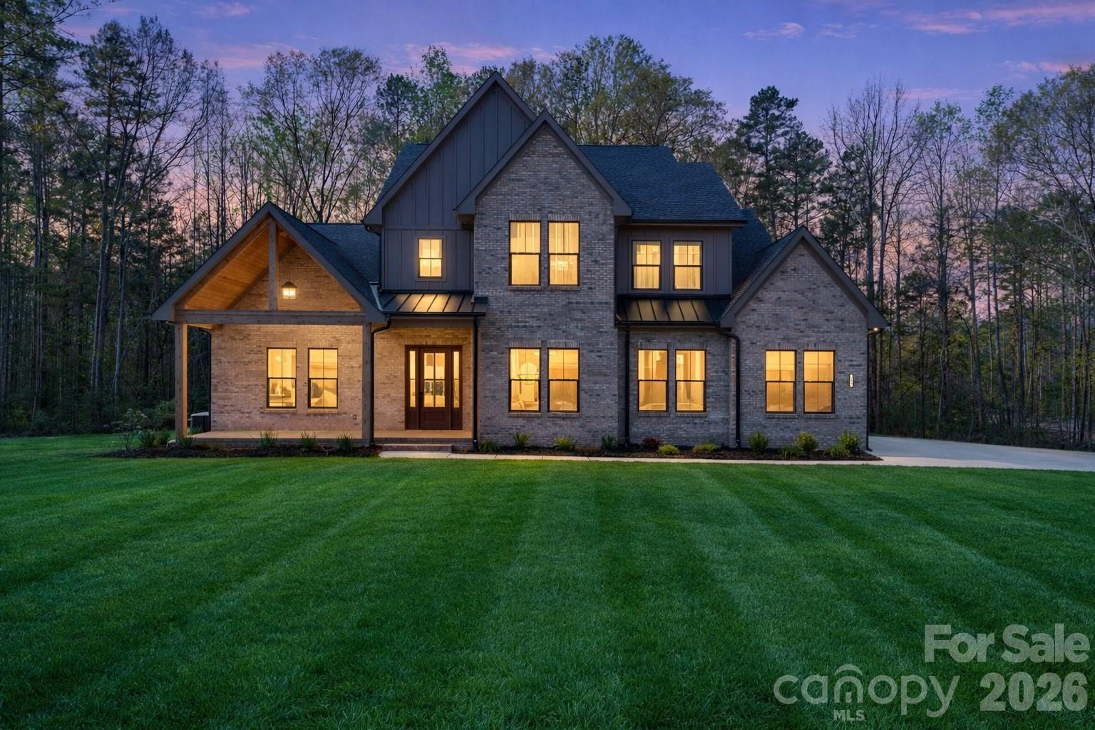 Situated on a premium corner homesite within an intimate 36-homesite community—where each residence enjoys over an acre—this exceptional property offers a rare blend of architectural presence, thoughtful design, and elevated everyday living in the heart of Clover.

From the moment you arrive, the covered front porch creates a warm, inviting introduction, while the home’s positioning on a corner lot enhances both privacy and curb appeal.

Inside, a stunning two-story great room anchors the home, filled with natural light and highlighted by a striking fireplace—creating a true focal point for both everyday living and entertaining.

The kitchen is nothing short of showpiece quality. A dramatic waterfall quartz island serves as the centerpiece, complemented by custom cabinetry that extends to the ceiling, designer lighting, and a professional-grade appliance package. A pot filler, farmhouse sink, and thoughtfully designed prep spaces combine functionality with elevated design—while a secondary prep area and walk-in pantry provide both convenience and clean, uncluttered living. This is a space built for entertaining at a high level.

The main-level primary suite offers a private retreat, featuring a spa-inspired bath with a soaking tub, walk-in shower, and refined finishes throughout.

Upstairs, additional bedrooms and flexible living spaces provide room for family, guests, or a home office—each space benefiting from the home’s thoughtful layout and flow.

Outdoor living continues with a covered rear porch overlooking the expansive homesite—ideal for relaxing, entertaining, or simply enjoying the quiet surroundings.

With full sod and irrigation, curated architectural details, and a level of craftsmanship rarely seen in the Clover market, this home delivers a true luxury experience—just minutes from dining, shopping, and everyday conveniences, with easy access to Charlotte.

This is more than a home—it’s a statement of design, quality, and lifestyle.