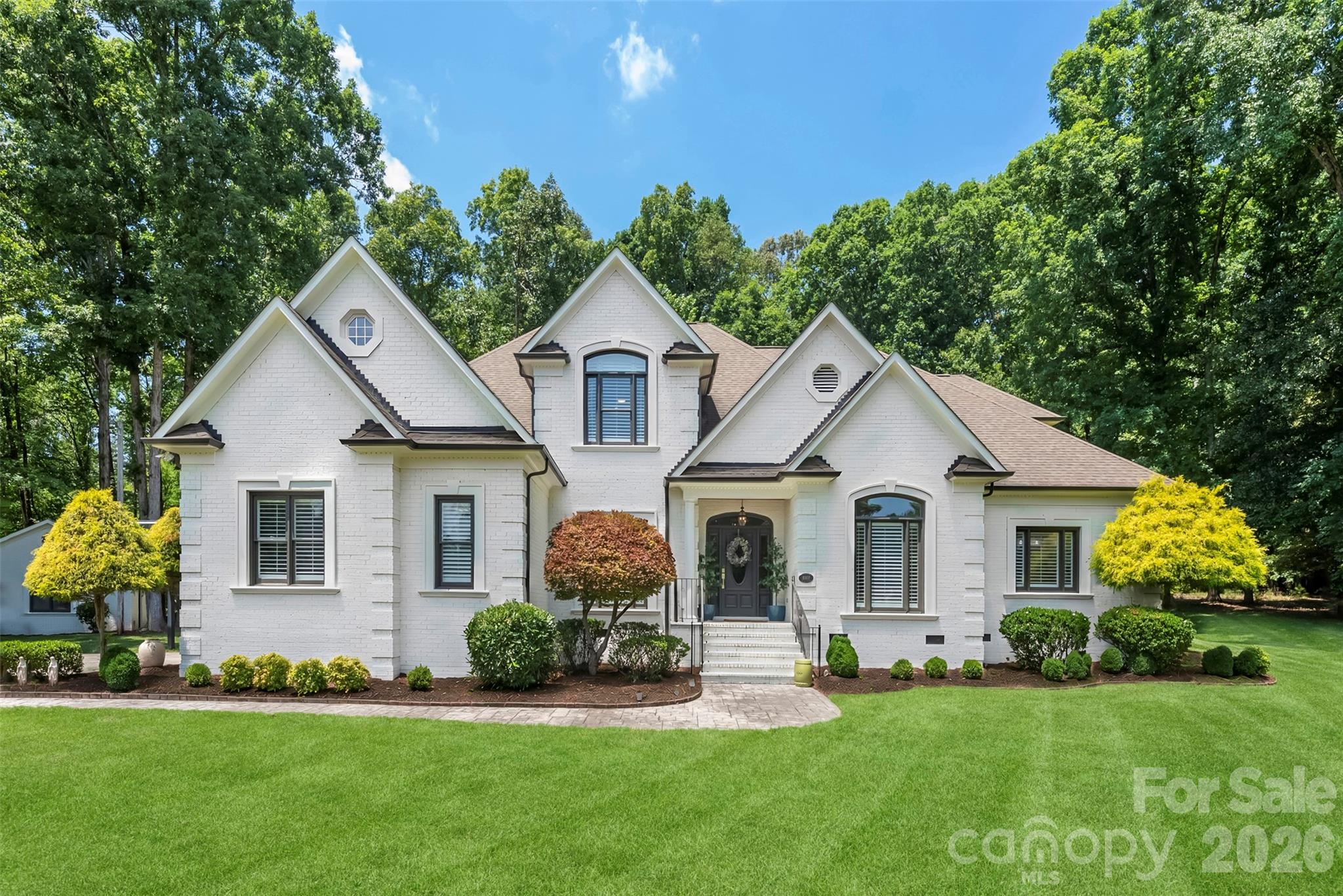 Experience resort-style living every day in this extraordinary custom estate, perfectly positioned on nearly 3 private, beautifully landscaped acres in the Pleasant Valley community. This exceptional property offers the rare combination of complete privacy and an incredibly convenient location—just minutes to Matthews, I-485, SouthPark, and Uptown Charlotte.

Recently renovated and designed for both grand entertaining and everyday living, the outdoor spaces are nothing short of spectacular. Enjoy a professionally designed resort-style pool and spa, covered cabana, expansive paver patio, fire pit, professionally landscaped grounds, and a private batting cage. A detached garage with air conditioning offers endless flexibility as a workshop, home gym, studio, or future guest retreat.

Inside, more than 2,700 square feet of thoughtfully designed main-level living showcases exceptional craftsmanship with extensive custom millwork, built-ins, HIGH ceilings, and elegant finishes throughout. The impressive home office features cathedral ceilings, while the inviting great room flows seamlessly into a chef's kitchen equipped with Wolf and Sub-Zero appliances, two dishwashers, an island, generous walk-in pantry, and a custom wet bar complete with a Sub-Zero wine refrigerator—perfect for effortless entertaining.

The luxurious main-level primary suite serves as a private retreat with a beautifully renovated spa-inspired bath and dual walk-in closets. A stunning screened porch provides the perfect place to relax and enjoy peaceful Carolina evenings overlooking the breathtaking backyard.

The upper level offers three spacious bedrooms, two full baths, a large bonus room, plus an additional finished flex room that can easily serve as a fifth bedroom, media room, or playroom. Exceptional storage includes a large walk-in attic and oversized attached garage.

Additional highlights include a whole-house Generac generator, newer HVAC system, fresh interior and exterior paint, impeccable landscaping, and meticulous maintenance throughout. Offering an unmatched blend of luxury, privacy, outdoor living, and everyday convenience, this is a truly one-of-a-kind estate that rarely becomes available.