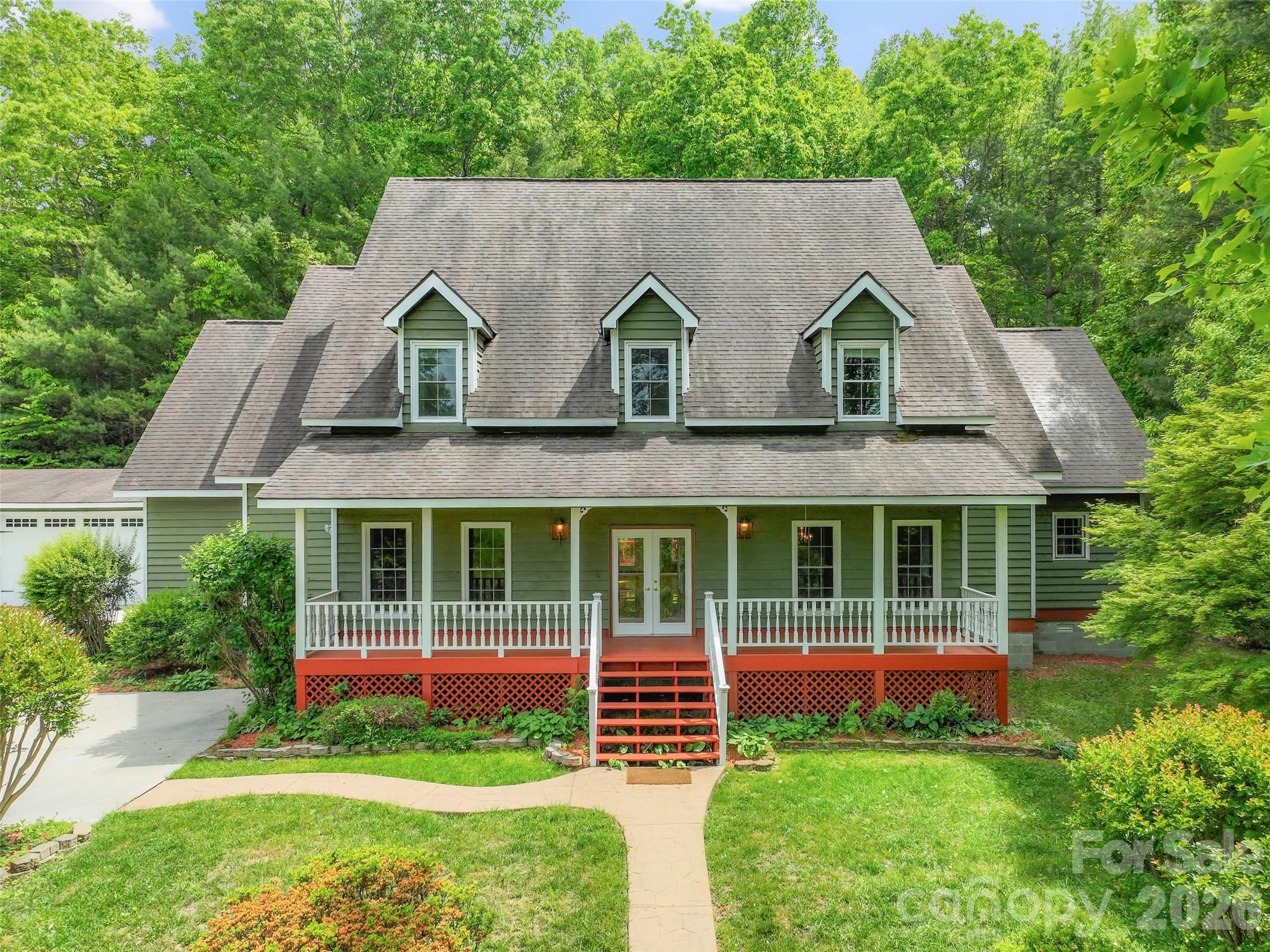 Welcome home to this private mountain retreat on 2.73 acres in the desirable Willow Road area of Hendersonville. This light and bright property features an abundance of windows that bathe many rooms in natural light. The heart of the home flows to beautiful outdoor living spaces, featuring a sparkling pool surrounded by lush, vibrant landscaping with gorgeous flowers from spring through fall. It is a gardener's paradise and an entertainer's delight. Inside, the expansive primary suite serves as a peaceful haven, complete with a fireplace, large his-and-hers closets, and an ensuite bathroom with a separate shower and soaking tub. With tall ceilings throughout and plenty of room to entertain. Upstairs are three bedrooms, including two with their own separate flex space. Breathtaking views of the Blue Ridge mountains from the spacious covered front porch. Car enthusiasts will love the oversized four-car garage plus a separate workshop with extra storage and a separate gym. There are fruit trees on the property including peach and pear trees. The attic can be fully finished out for more space, a playroom, or extra storage. There is a level RV parking spot with power for a large RV between the garage and workshop/gym. This listing contains digitally altered and staged photos.