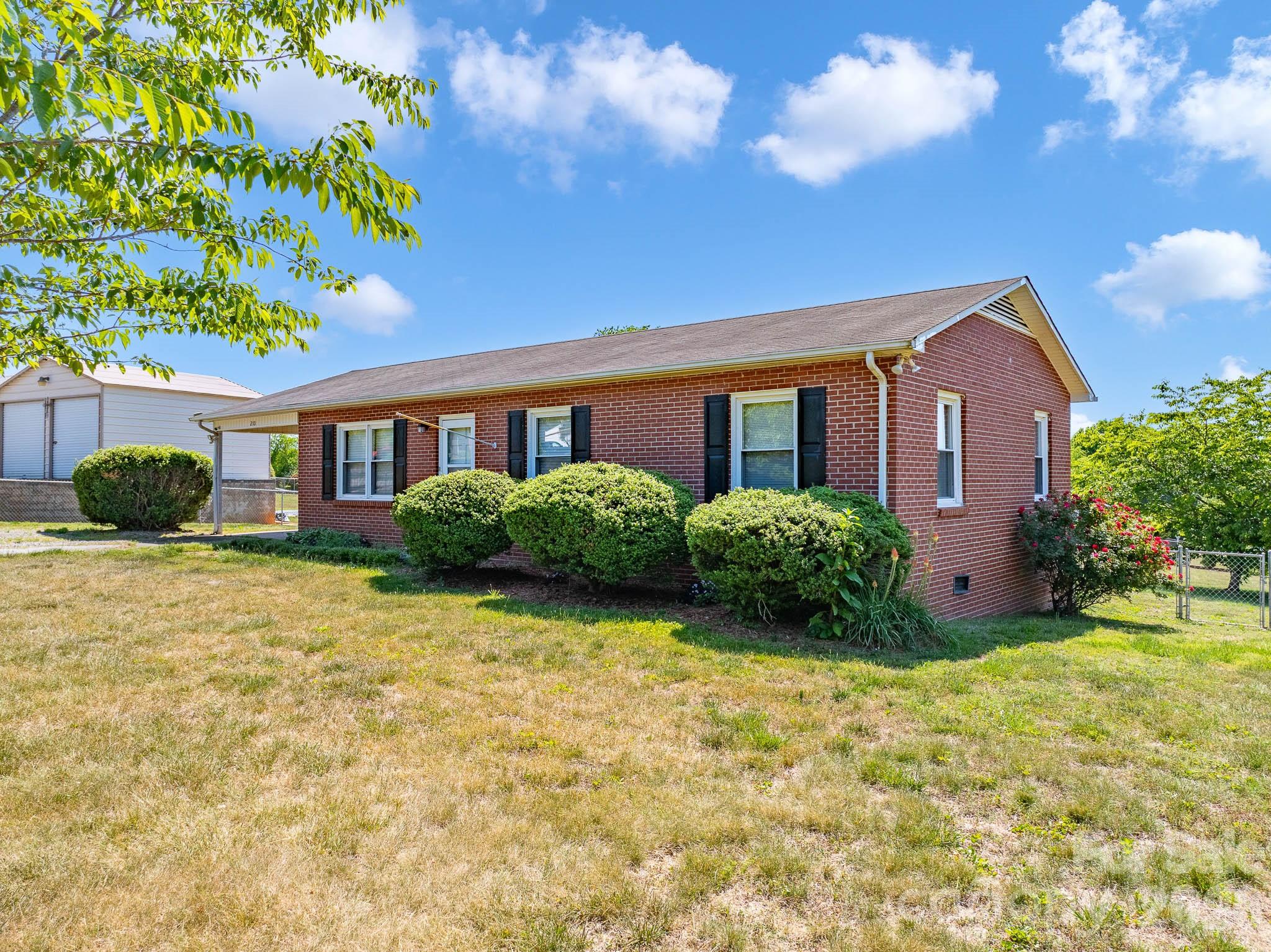 Welcome home to this well-maintained brick ranch offering easy one-level living on a cleared corner lot with a spacious, fully fenced backyard—perfect for kids, pets, or outdoor entertaining. Convenient entry from the carport leads directly into the kitchen and dining area, making grocery trips simple in any weather. Inside, you'll find three bedrooms and two full baths, including one with a tub/shower combo and another with a walk-in shower for added comfort and accessibility. 

The property also includes a barn-shaped outbuilding with power, ideal for storage, a workshop, hobby space, or additional work area.

Conveniently located between the towns of Lenoir and Morganton, both less than a 20-minute drive, and only 30 minutes to Hickory, this charming home offers the perfect blend of comfort and accessibility. Whether you're searching for your first home, downsizing, or looking for the perfect retirement retreat, this one checks all the boxes.