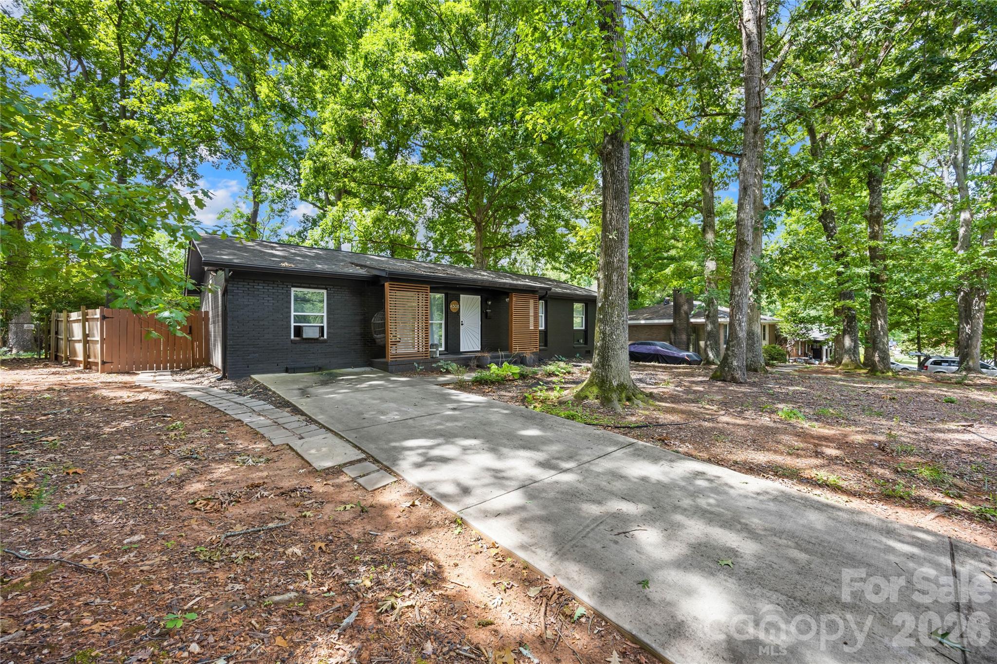 Set on a private, tree-lined cul-de-sac lot in Robinhood Woods, this one-level ranch offers a comfortable, easy-flowing layout with 4 bedrooms and 3 full baths. A welcoming front porch opens into the living room, where laminate wood flooring and a smoke-free gel-fuel fire stove add warmth and character. The adjoining kitchen features an island, built-in storage and an open connection to the spacious family room, creating an inviting central gathering space with direct access to the rear deck. The primary bedroom is privately positioned on one side of the home with its own full bath, while a separate hallway leads to three additional bedrooms and two more full baths. A 4-person interior sauna brings an unexpected wellness retreat to the home, complemented by practical features including an interior laundry closet, walk-in closets and additional storage. Outside, the deck and patio overlook a level, fully fenced backyard shaded by mature trees, with a storage shed, rainwater catchment system and rustic outdoor brick oven ready for relaxed evenings and open-air cooking.