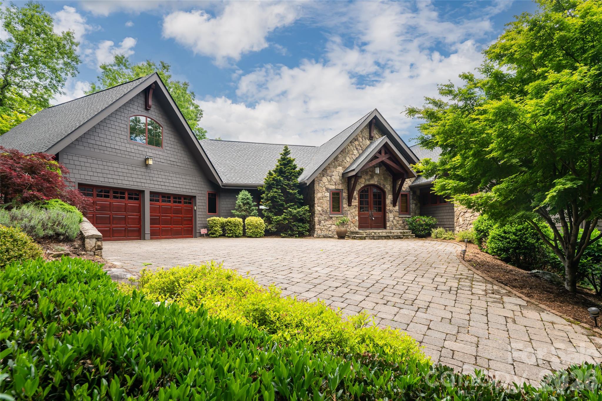 Tucked away in a private, wooded setting, this stunning four-bedroom mountain retreat offers the perfect blend of luxury, comfort, and natural beauty. Thoughtfully designed with warm wood finishes, soaring vaulted ceilings, and expansive windows that bring the outdoors in, this home captures the essence of refined mountain living. The spacious great room is anchored by a dramatic stone fireplace and flows seamlessly into the chef’s kitchen featuring custom cabinetry, beautiful stonework, and inviting gathering spaces ideal for entertaining.

Enjoy peaceful mornings and cool mountain evenings surrounded by nature from the home’s multiple outdoor living areas, all while being just moments from exceptional community amenities. Residents enjoy access to scenic walking trails, a beautiful outdoor pool, fitness center, clubhouse, and even a picturesque 40ft waterfall just a short walk away, creating a true mountain lifestyle experience. Whether you are seeking a full-time residence or luxurious mountain escape, this secluded property offers unmatched privacy, timeless craftsmanship, and the serenity of mountain living at its finest.