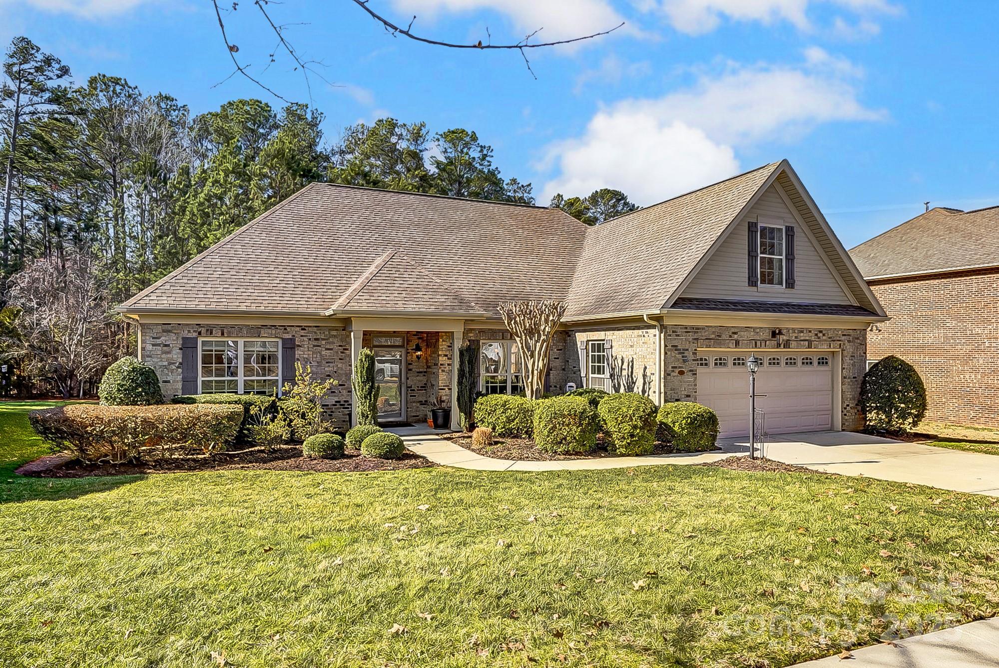 This all-brick ranch-style home in Riverwood offers 4 bedrooms w/ 4th bedroom/bonus room upstairs &  2.5 baths. The open floor plan features a dining room, family room with a gas fireplace, and a kitchen with granite countertops, an island, and stainless appliances. The primary bedroom is on the main floor with an ensuite bath, double vanities, soaking tub, separate shower, and walk-in closet. Two additional bedrooms, a full bath, and a half bath are also on the main level. A mudroom/laundry with extra pantry space adds convenience. Enjoy the screened-in back porch with vinyl enclosure panels, extended patio with pergola, and a mostly fenced, wooded yard with irrigation for easy maintenance and privacy. Benefit from low York County taxes, and easy access to I-77, schools, restaurants, retail, and the upgraded Ebenezer Park for Lake Wylie enjoyment.
