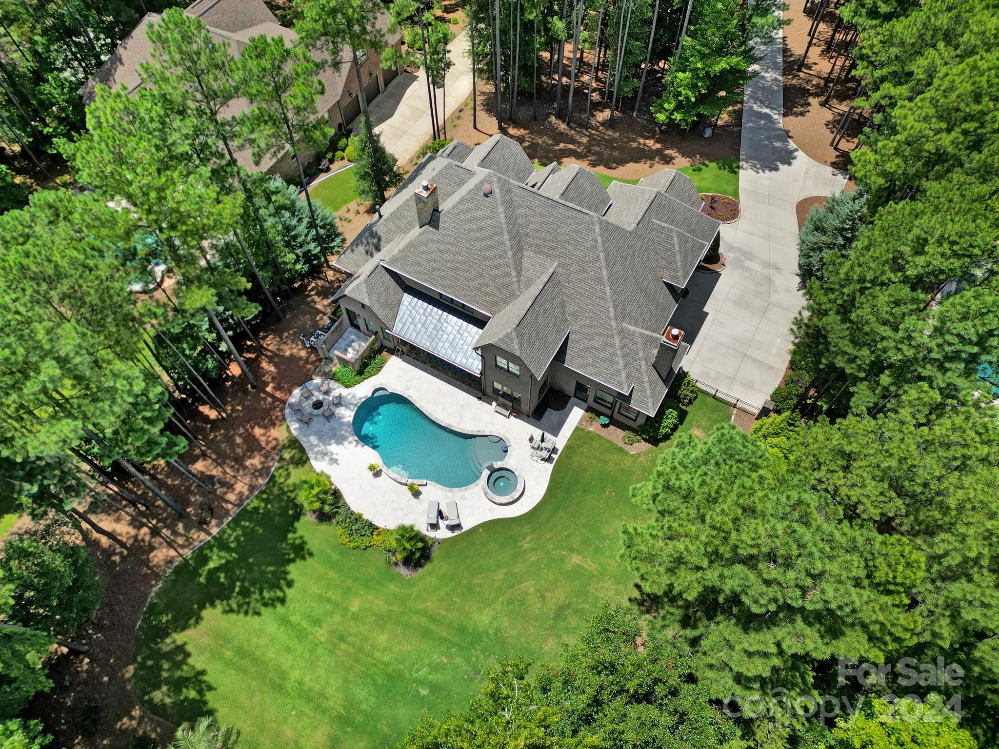 Back On Market - Buyers Sales Contingency Fell Through! Luxury custom-built home in Fort Mill’s desirable Trinity Ridge. This breathtaking home is full of rich design, custom finishes, style & meticulously maintained. Upgrades include beautiful hardwood floors (in all rooms except bonus & wet rooms); gourmet kitchen with marble island, arch stone wall over gas cooktop; designer light fixtures; heavy moldings; shiplap ceilings; custom closet systems, surround sound; 3 fireplaces (living, sunroom, primary) & epoxy garage floors. Primary suite on main with tranquil stone spa shower, dual vanities, soaking tub & private patio. Butler’s pantry with sub zero wine fridge & wine closet. 3 bedrooms up all with ensuite baths, bonus & media could also be converted to bedrooms. Wet bar with beverage center in the media room. Outdoor paradise featuring pool, hot tub, fire pit, travertine patio, covered porch with outdoor kitchen overlooking a private, wooded backdrop. Tons of storage. 3 car garage.