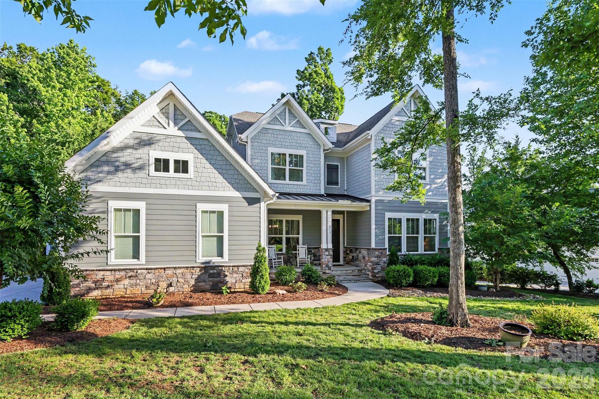 113 Cross Current presents a rare opportunity to experience elevated living in the highly desirable McLean–South Shore waterfront community, where residents enjoy lake access, a private kayak launch, and resort-inspired amenities designed for a relaxed yet luxurious lifestyle. Conveniently situated near Charlotte, Charlotte Douglas International Airport, Belmont, and the beautiful Daniel Stowe Conservancy, this location offers the ideal blend of peaceful retreat and everyday accessibility, with marinas and endless waterfront recreation just minutes away.
Beautifully maintained and thoughtfully crafted, the home offers a sophisticated yet functional layout. The expansive primary suite serves as a private retreat, featuring a luxurious spa-inspired ensuite bathroom designed with comfort and relaxation in mind. Every bedroom is designed with its own walk-in closet and direct bathroom access, creating a comfortable and private experience for both residents and guests. Generous living spaces and flexible-use areas provide the versatility needed for entertaining, remote work, or quiet relaxation. 
At the heart of the home, the chef’s kitchen impresses with an expansive island, butler’s pantry, and effortless connection to the surrounding living and gathering spaces. The open-concept design is complemented by a stunning stone fireplace and a built-in drop zone that adds both charm and convenience to daily living. Adding to the home’s appeal is a whole-house reverse osmosis water filtration system, providing high-quality water throughout.
Practicality meets style with abundant, easily accessible storage, a spacious three-car garage, and an oversized driveway offering ample parking. Outdoors, enjoy the covered porch with ceiling fan overlooking a private, level backyard surrounded by mature trees. A cozy fire pit creates the perfect setting for relaxing evenings or entertaining under the stars. Combining timeless finishes, thoughtful design, and an exceptional waterfront community lifestyle, this home truly stands apart.