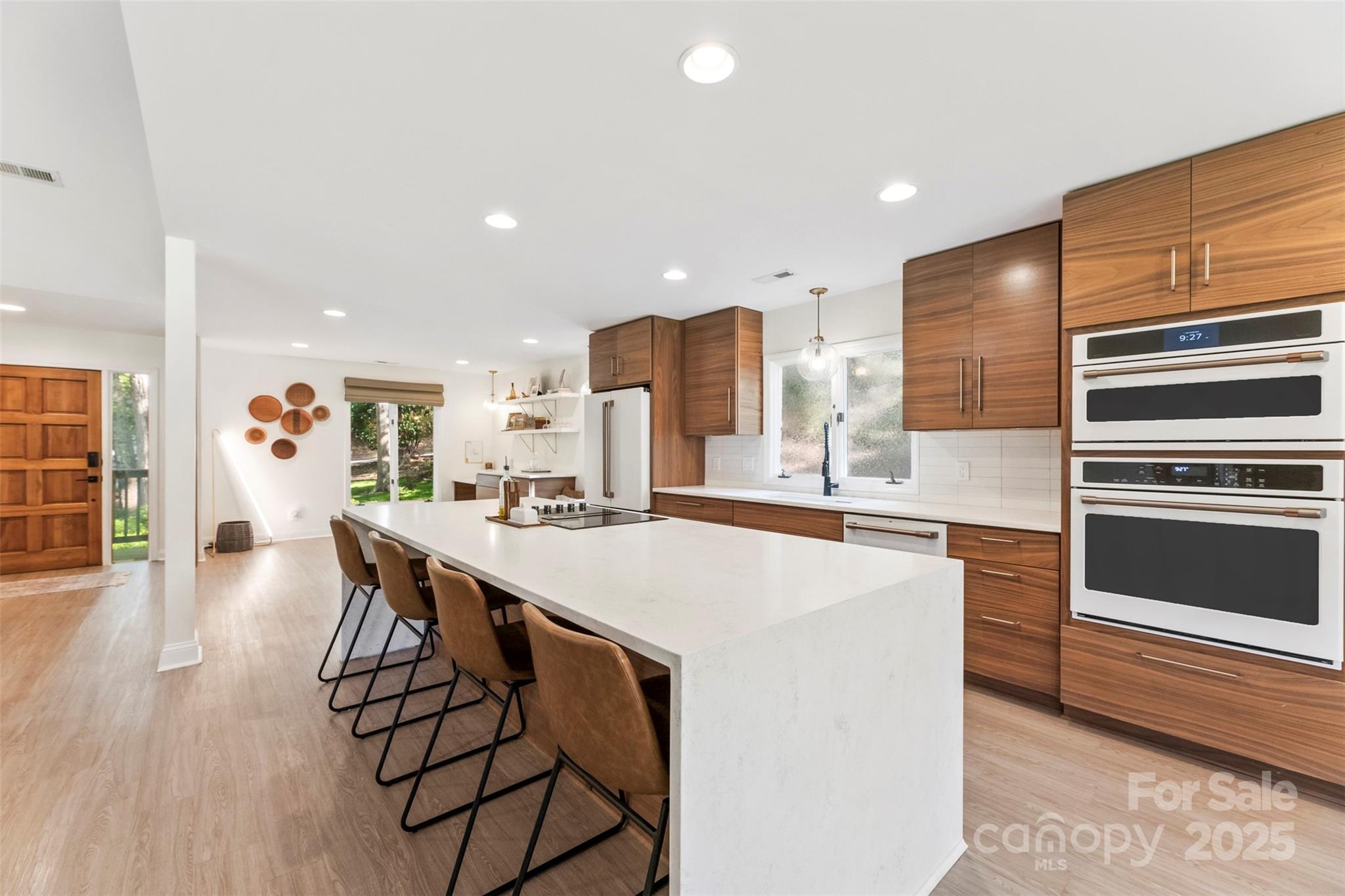 Welcome to this updated ranch w/walk out basement on quarter acre+ w/big views of the 18-hole championship golf course. The kitchen—a true showstopper w/waterfall quartz countertops, LVP flooring, white Café appliances, walnut cabinetry, & eclectic diner-style pantry doors framing coffee & wine bar. Open to vaulted living room w/gas fireplace, perfect for relaxing or entertaining. Step out onto the expansive deck offering panoramic golf course views. Main level offers 3 sunlit bedrooms, a spacious primary suite w/grasscloth wallpaper, direct deck access, ample closet space, & en suite bath w/floor-to-ceiling tiled shower & dual vanity. Head downstairs where you’ll find a cozy den w/fireplace, bedroom & full bath, & easy access to patio for relaxing under the bistro lights. This home blends comfort, style, & golf course living. River Hills offers a 24-hour gated community, private golf & country club, marina, walking trails, a sandy beach, playgrounds, gardens, & top-rated schools.