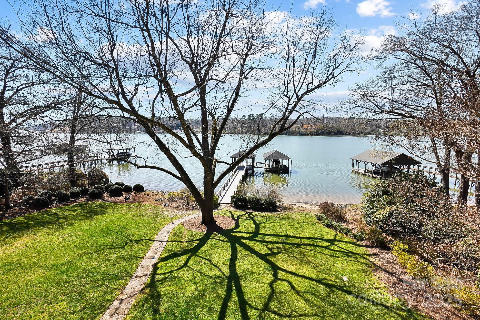 Experience unparalleled luxury living in this magazine-worthy lakefront estate. Exquisite architectural details, hardwood floors, intricate moldings & breathtaking views permeate every room. The soaring 2-story great room w/ fireplace & built-in cabinetry seamlessly flow to formal dining room, setting the stage for unforgettable gatherings. Awaken your inner chef in the gourmet kitchen equipped w/ss  appliances, gas cooktop, wall oven & Viking oven. The center island, breakfast bar & 2 pantries provide ample space for culinary creations, all while enjoying the captivating lake views. Retreat to the luxurious primary suite w/ spa-like bath. Upstairs the loft, 2 BRs & huge bonus room offer accommodations for guests or family. Embrace the outdoor lifestyle on the balcony, unwind in the screened porch or host gatherings on the spacious deck. Covered dock w/ boat lift & jet ski lift invites you to explore the waters of Lake Wylie. Fantastic location minutes from I85, I485, Uptown & airport.
