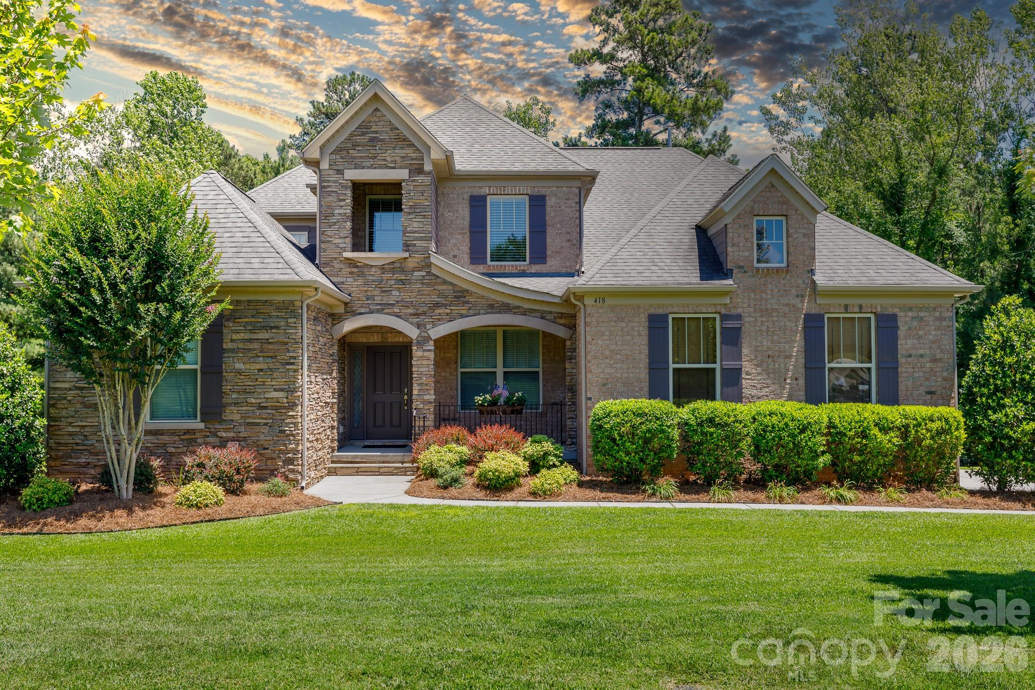 Welcome home to Waterford Glen, where resort-style community living meets your own private everyday retreat. This open-floorplan home sits on a generous half-acre lot that backs up to a quiet wall of mature trees, giving you a beautiful, private wooded view. From the moment you step inside, the home feels grand yet welcoming, opening up to a bright, two-story great room. Everyday life flows naturally into the gourmet kitchen, which features granite countertops, a central work island, a breakfast bar, a gas range, a wall oven combo, and a spacious pantry. Right off the kitchen, a cozy living room anchored by a beautiful fireplace offers the perfect spot to unwind. The main level provides rare flexibility with two full bedrooms downstairs, including a peaceful primary suite. This main-level retreat features elegant tray ceilings, dual sinks, a granite-topped vanity, a deep garden tub, a tiled shower, and a large walk-in closet with its own secondary door leading right into the laundry room for ultimate convenience. Upstairs, a spacious loft serves as a fantastic secondary living area for games, movies, or casual relaxation. When you want to enjoy the beautiful outdoors, you are completely spoiled for choice. Step out onto the screened back porch for your morning coffee, relax on the side deck, or host unforgettable gatherings on the custom paver patio, which comes fully equipped with an outdoor fireplace and a built-in grill. With a community pool, a golf course winding right through the neighborhood, and shopping, dining, and the interstate just minutes away, this home perfectly balances daily convenience with an elevated, relaxed lifestyle.