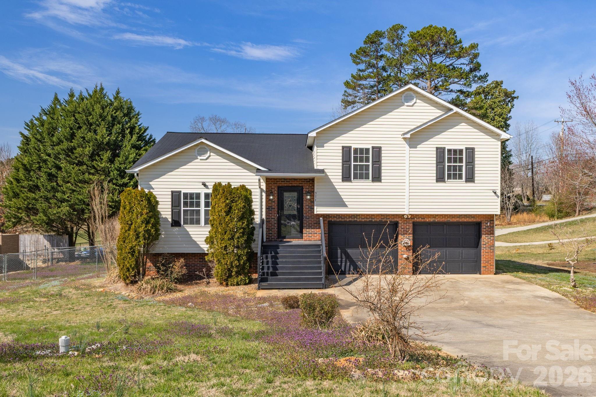 Price Reduced $329,900. Seller offering an additional $8,000 buyer credit.  Welcome to 311 N Meadow Drive Morganton, NC 28655 — an updated, move-in ready 3-bedroom, 2-bath home offering modern finishes, flexible living space, and a spacious lot in a desirable small-town setting.

Step inside to a bright, open main level featuring durable luxury vinyl plank flooring throughout—no carpet—creating a clean, contemporary feel that’s both stylish and low-maintenance. The inviting living room centers around a cozy gas fireplace, perfect for relaxing evenings or hosting guests. The kitchen and bathrooms are accented with tasteful tile finishes, blending warmth and timeless appeal.

The lower level adds valuable versatility with a large bonus space featuring sleek painted concrete floors—ideal for a second living area, home office, gym, media room, or playroom. Whether you need extra space to spread out or entertain, this home adapts to your lifestyle.

Enjoy outdoor living with a 14’ x 8’ rear deck—perfect for grilling, entertaining, or unwinding. The fenced backyard is great for pets or play, while the expansive side yard offers additional space for gardening, recreation, or added privacy. Convenient under-deck storage provides plenty of room for tools and equipment.

Additional highlights include a double-car garage, low-maintenance vinyl siding, energy-efficient double-pane windows, and a gas furnace with central air for year-round comfort.

Located in charming Glen Alpine, you’ll enjoy the benefits of small-town living with lower taxes and convenient services, all just minutes from shopping, dining, and easy access to nearby amenities.

Offered at $329,900, this home delivers the perfect combination of comfort, space, and flexibility—schedule your showing today.