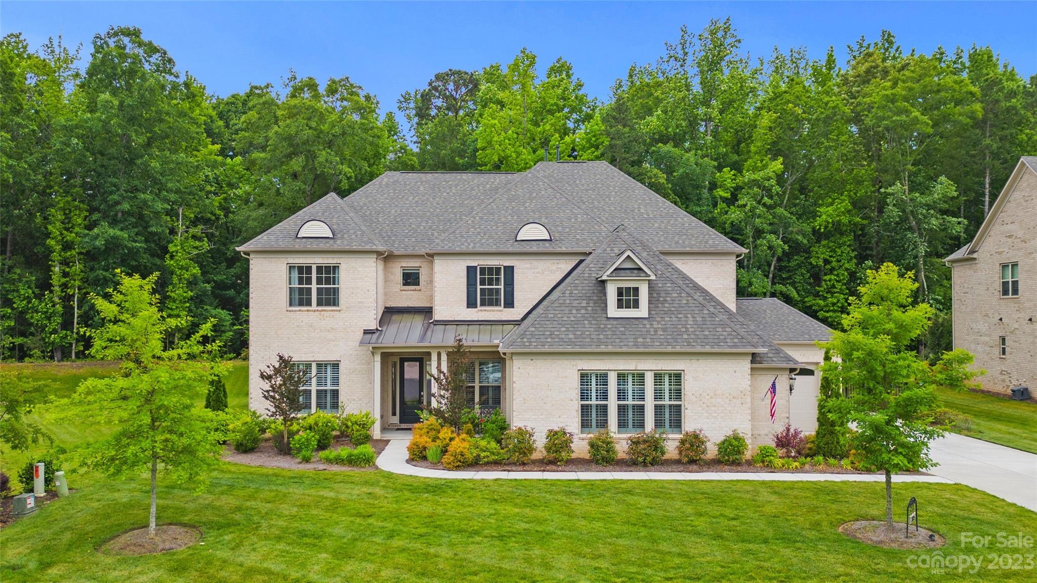 Introducing the desirable Harrington floor plan, located in the most sought-after neighborhood in Indian Land, Bridgemill. Built in 2019, this home is situated on a culdesac lot that backs up to private woods. This full brick home features a spacious 3-car garage, complete with an EV charger. The open floor plan awaits, creating a seamless flow throughout the home with the primary bedroom on the main floor and a large kitchen equipped with Kitchen-Aid appliances with plenty of room for entertaining. This home has every upgrade imaginable, from builder upgrades to owner upgrades. The upper level includes an additional 4 bedrooms with a fully equipped surround system theater room. The neighborhood itself is a true haven, offering a wide range of amenities to cater to all lifestyles. Residents can enjoy two community pools, tennis courts, a clubhouse, fitness center features, upgrades, and a wealth of amenities, this home offers a truly exceptional lifestyle.