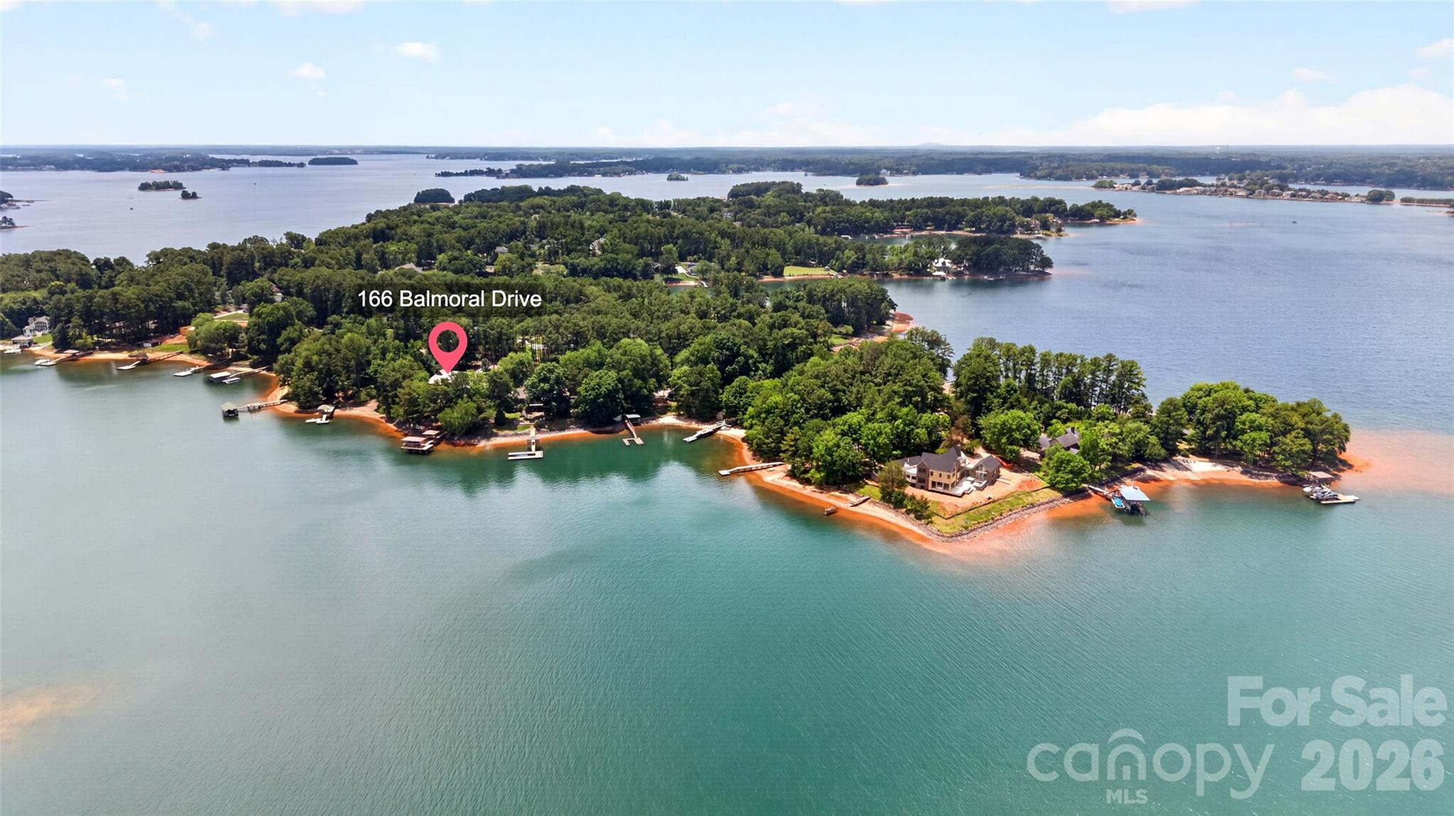 Experience waterfront living at its finest in this custom-built Lake Norman home, complete with a covered pier and covered boat slip. Situated on a beautiful, level 0.73-acre lot just off the main channel, this exceptional property offers breathtaking water views and multiple outdoor living spaces designed for year-round enjoyment.

Relax on the main-level screened porch featuring a cozy fireplace, entertain on the expansive lakeside deck, unwind in the hot tub on the lower-level screened porch, or take in the scenery from the covered patio below. With stunning waterfront views from nearly every outdoor space, this home perfectly blends luxury, comfort, and lakefront living.

Inside, the main level welcomes you with a dramatic great room featuring soaring two-story ceilings, a fireplace, and an open-concept layout ideal for both everyday living and entertaining. The spacious kitchen is thoughtfully designed with abundant cabinetry, expansive countertop space, double ovens, a full range, and a walk-in pantry complete with a full-size refrigerator and extensive shelving for exceptional storage. Just off the main living areas, a generously sized drop zone provides additional built-in cabinetry and organizational space, keeping everyday essentials neatly tucked away. Two private offices and a convenient half bath complete the main level, offering flexibility for remote work and daily living.

Upstairs, the primary suite serves as a private retreat overlooking the lake. The expansive bedroom captures beautiful water views and features dual walk-in closets. The spa-inspired primary bath includes a large soaking tub, a spacious walk-in shower, and elegant heated tile floors. The upper level also includes the primary laundry room and an adjoining unfinished flex space, offering endless possibilities for future expansion, a hobby room, exercise space, or additional storage.

The lower level is thoughtfully designed for guests and entertaining, featuring two guest bedrooms. One bedroom includes a private ensuite bath, while a second full bathroom is conveniently located off the hallway. A spacious family room with a wet bar provides the perfect gathering space and overlooks the screened porch and hot tub area, creating a seamless connection between indoor and outdoor living. A second laundry room on the lower level adds convenience for guests and extended stays.

Luxury details continue throughout the home, including heated tile floors in all bathrooms, providing comfort year-round. Storage is abundant with five dedicated storage rooms located throughout the home, offering exceptional space for seasonal items, lake gear, hobbies, and everyday organization.

Outdoor enthusiasts will appreciate the lower-level utility garage, perfect for storing a lawnmower and landscaping equipment. A dedicated wash pad allows for easy cleanup and maintenance after yard work, helping keep equipment and outdoor spaces in top condition.

Combining thoughtful design, generous living spaces, exceptional storage, premium amenities, and an unbeatable location on Lake Norman, this remarkable waterfront property offers the ultimate lakefront lifestyle. Whether you're entertaining family and friends, working from home, or simply enjoying the peaceful waterfront setting, this home delivers a rare opportunity to experience luxury lake living at its best.
