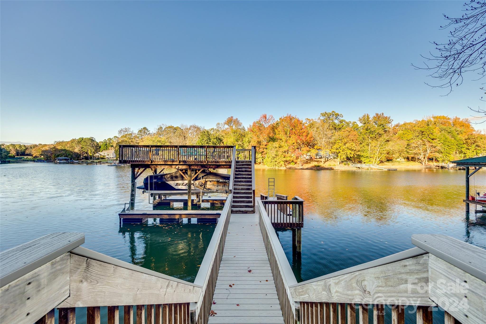 Discover the epitome of lakeside living! This property exudes tranquility and seclusion but is just seconds to the main channel by water!  Updated 4-bed, 2 bath retreat boasts breathtaking waterfront views with natural light streaming through all the lakeside windows. Tucked away in a quiet cove with 82 ft. of shoreline with rip rap for stabilization with no through boat traffic. Easy walk to the water from the house. Great year round deep water, double decker dock with approx 16' in water depth and oversized floating swim platform. Boat slip with 2-motor 8,000 lb lift with aluminum bunks on risers. Entertain on one of the north facing multiple covered & open decks with a gas line for your grill or fire table and mounted TV for year long enjoyment. Features- new luxury vinyl plank flooring on main, painted white kitchen cabinets, newer windows & doors, cement board siding, insulation, 4x exterior retaining walls, Rinnai tankless hot water heater and so much more!