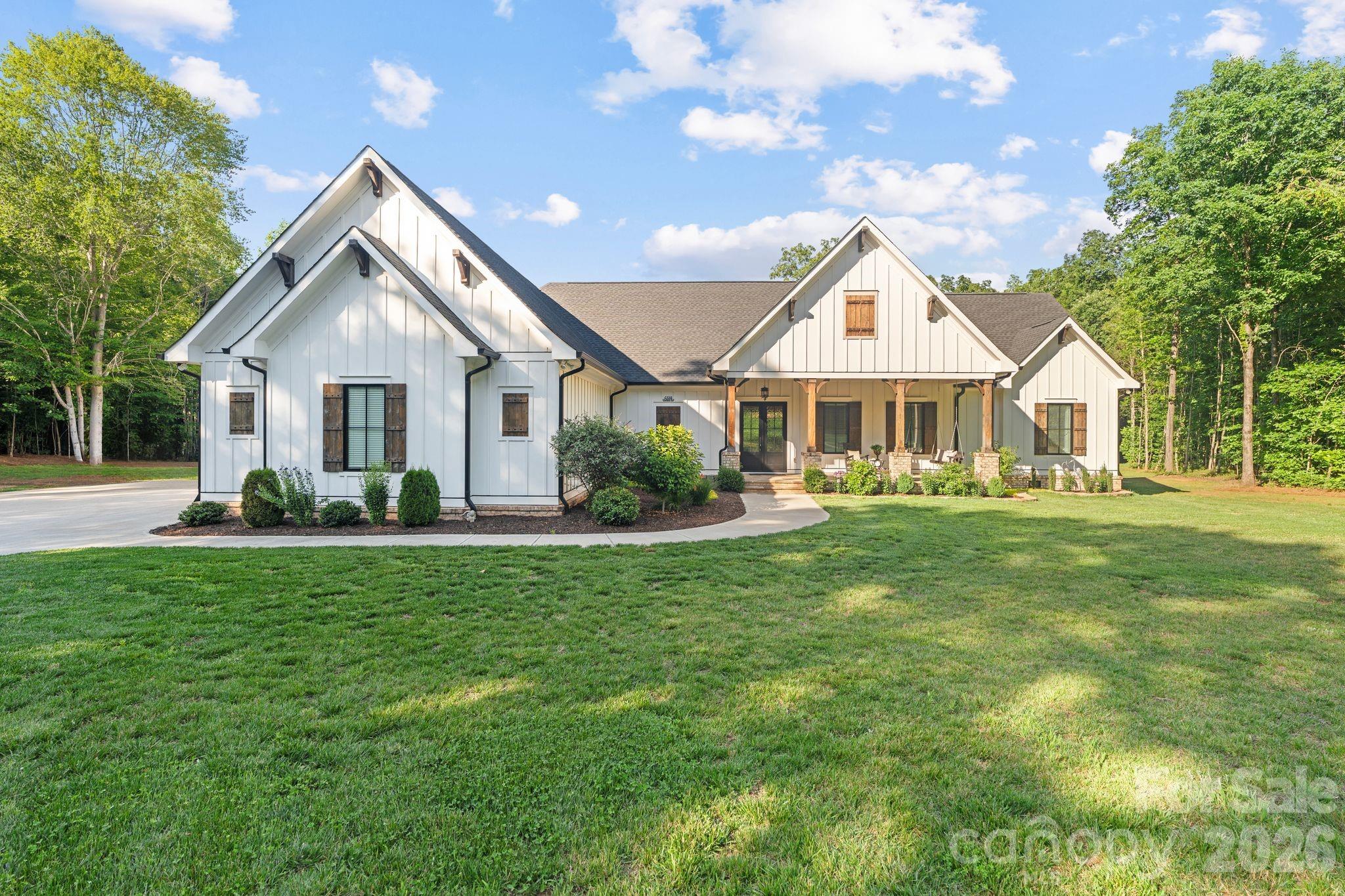 Tucked away at the end of a picturesque gravel drive winding through the woods, this extraordinary custom built estate offers the perfect blend of luxury, privacy, and craftsmanship on 18.5 breathtaking acres. Built by the owner builder in 2022, every detail was thoughtfully designed to create a home that is as functional as it is beautiful. The spacious main level features an inviting open concept layout centered around a stunning great room with fireplace, a chef's kitchen with oversized island, walk in pantry, and a dining area designed for gathering. The private primary suite offers a spa inspired bath and generous walk in closet, while a dedicated laundry room and custom mudroom add everyday convenience. On the opposite wing of the home, two secondary bedrooms share a full bath, creating an ideal split bedroom floor plan. Upstairs, you'll find a large guest suite with private bath, an expansive bonus room, a versatile flex space currently used as a gym, and abundant walk in heated and cooled storage. Architectural details abound throughout, including rich wood flooring, exposed beams, custom built ins, designer lighting, and exceptional millwork. Outdoor living is equally impressive with a welcoming covered front porch complete with a swing, a screened rear porch, and sweeping views of the surrounding acreage. A rare offering, this private retreat combines the tranquility of country living with the quality and finish level typically reserved for luxury custom homes. Experience the feeling of arriving at your own secluded estate while remaining convenient to Denver, Lake Norman, and Charlotte. New survey on file reflecting acreage separation and revised property boundaries. See survey for details. Acreage shown is based on the newly surveyed tract.