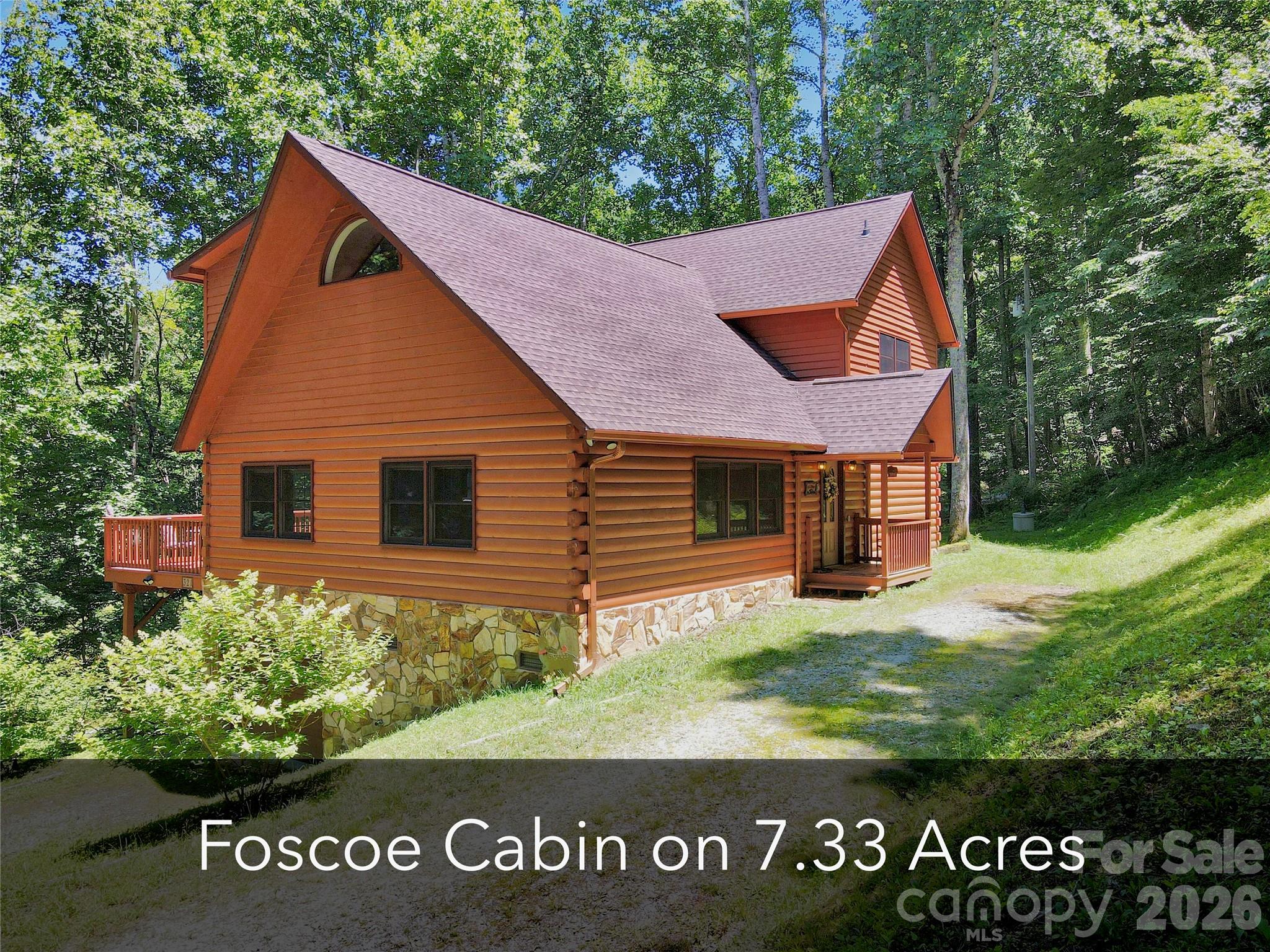 Unique Foscoe log cabin opportunity on 7.33 acres backing up to Grandfather Mountain State Park land. Ideally located between Boone and Banner Elk, this 3 bedroom, 2.5 bathroom cabin offers over 2,200 square feet of living space, an oversized 2-car garage, seasonal mountain views, and room to enjoy, expand, or create a true High Country retreat. With no HOA, no deed restrictions, light Foscoe-Grandfather zoning, and short- and long-term rentals permitted, this property offers excellent flexibility for personal use, investment, or future buildout. The cabin features a desirable open floor plan with one-level living, vaulted ceilings, warm wood accents, abundant windows for natural light, and a gas fireplace in the main living area. The main level includes a generously sized living room, dining area, pantry, laundry room, guest half bath, and spacious primary suite with en-suite bathroom and walk-in closet. A large 550+ square foot deck is accessed from both the main living area and primary bedroom, creating a great outdoor living space with wiring already in place for a hot tub. Upstairs offers two additional bedrooms, a full bathroom, and a large loft area, providing excellent space for guests, office use, or a second living area. The land is a special part of this offering, with a mix of flat and sloping terrain, a natural wooded setting, beautiful rock outcroppings, a creek, and additional potential building sites. Seasonal mountain views may be enhanced with selective tree work. The oversized basement garage offers room for two vehicles stacked, storage, workshop space, or mountain toys. Whether you envision a generational homeplace, guest cabins, rental opportunities, or simply keeping the acreage natural and private, this property provides a rare combination of acreage, location, flexibility, and proximity to Grandfather Mountain State Park. Minutes from grocery, restaurants, parks, Grandfather Vineyard, and more, with Boone and Banner Elk approximately 15 minutes away.