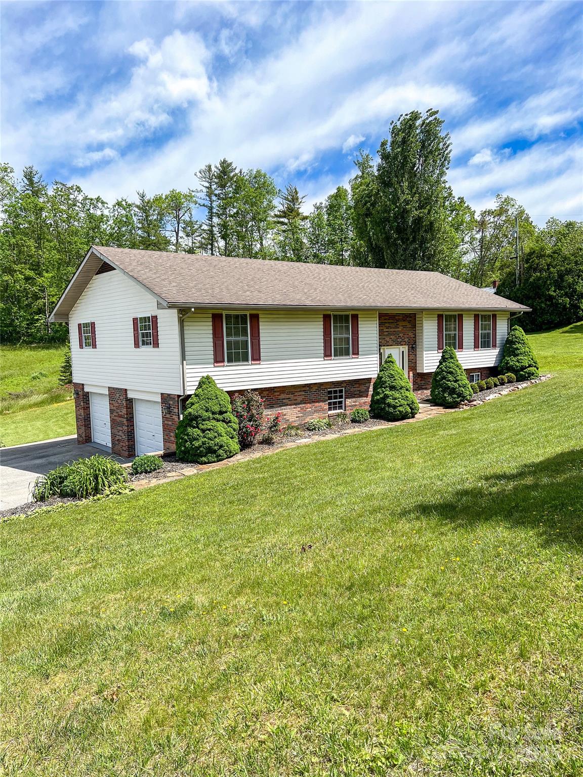 Located in one of the most desirable areas of Spruce Pine, NC, this impeccably maintained home offers convenient access to the Blue Ridge Parkway and shopping in Grassy Creek. The property features 4 spacious bedrooms, 3 full bathrooms, and 2 well-appointed kitchens. Additional highlights include beautiful hardwood floors, a back deck perfect for relaxing or entertaining, a storage shed, and meticulously landscaped grounds. The basement includes a two-car garage and a separate apartment, ideal for guests or rental income.