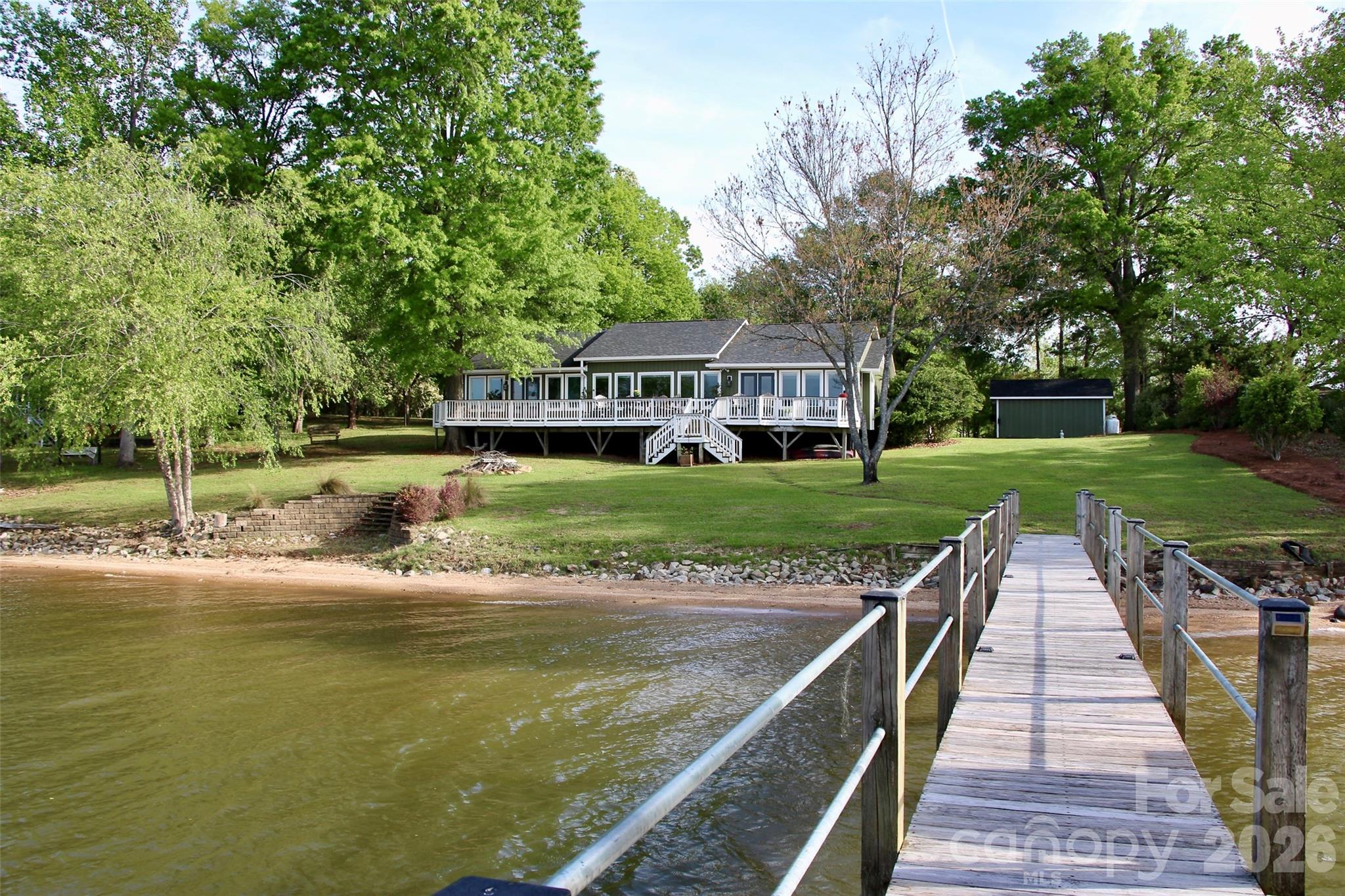 Welcome to your private waterfront retreat on scenic Lake Wateree, nestled in the historic charm of Liberty Hill, South Carolina. This beautifully maintained 4-bedroom, 2-bath home offers the perfect blend of comfort, functionality, and breathtaking natural beauty.

This home is well-appointed with features that matter most. Set on a gently sloping lot with an impressive 152 feet of protected shoreline, this property showcases sweeping big-water views and year-round deep water at the dock—ideal for boating, fishing, swimming and lake living at its finest. The private stationary dock is thoughtfully equipped with three remote-controlled lifts, including two for boats and one for a personal watercraft, with one lift covered for watercraft protection.

Outdoor living shines here, with a full-width deck and covered porch perfect for relaxing or entertaining while enjoying the peaceful surroundings. Majestic mature oaks and river birch trees provide shade and a stunning natural backdrop, while the outdoor fire-pit, and sandy beach create a resort-like setting for swimming and lakeside enjoyment.

Inside, the 2,346 heated square feet features an inviting open floor plan with durable LVP flooring throughout. The bright spacious kitchen is a standout, complete with high-end appliances, gas cooking, a large granite island, and plenty of room to gather. The owner’s suite offers a private retreat with walk-in side-by-side closets, an en suite bath, with beautifully tiled shower and luxurious whirlpool tub.

This home is as practical as it is beautiful, with major upgrades completed in 2020 including HVAC, architectural shingle roof, gutters, and board-and-batten vinyl siding. A whole-home generator ensures uninterrupted comfort, automatically powering all systems during outages.

Additional features include a lake-fed irrigation system, basement storage, detached garage/workshop, and ample RV and boat parking with a 50-amp hookup. The paved driveway and shoreline protection add convenience and peace of mind.

Whether you're seeking a full-time residence or a weekend getaway, this exceptional Lake Wateree property offers the ultimate in waterfront living—where every day feels like a vacation. Message for details or a private showing before its gone! Agent is owner.
