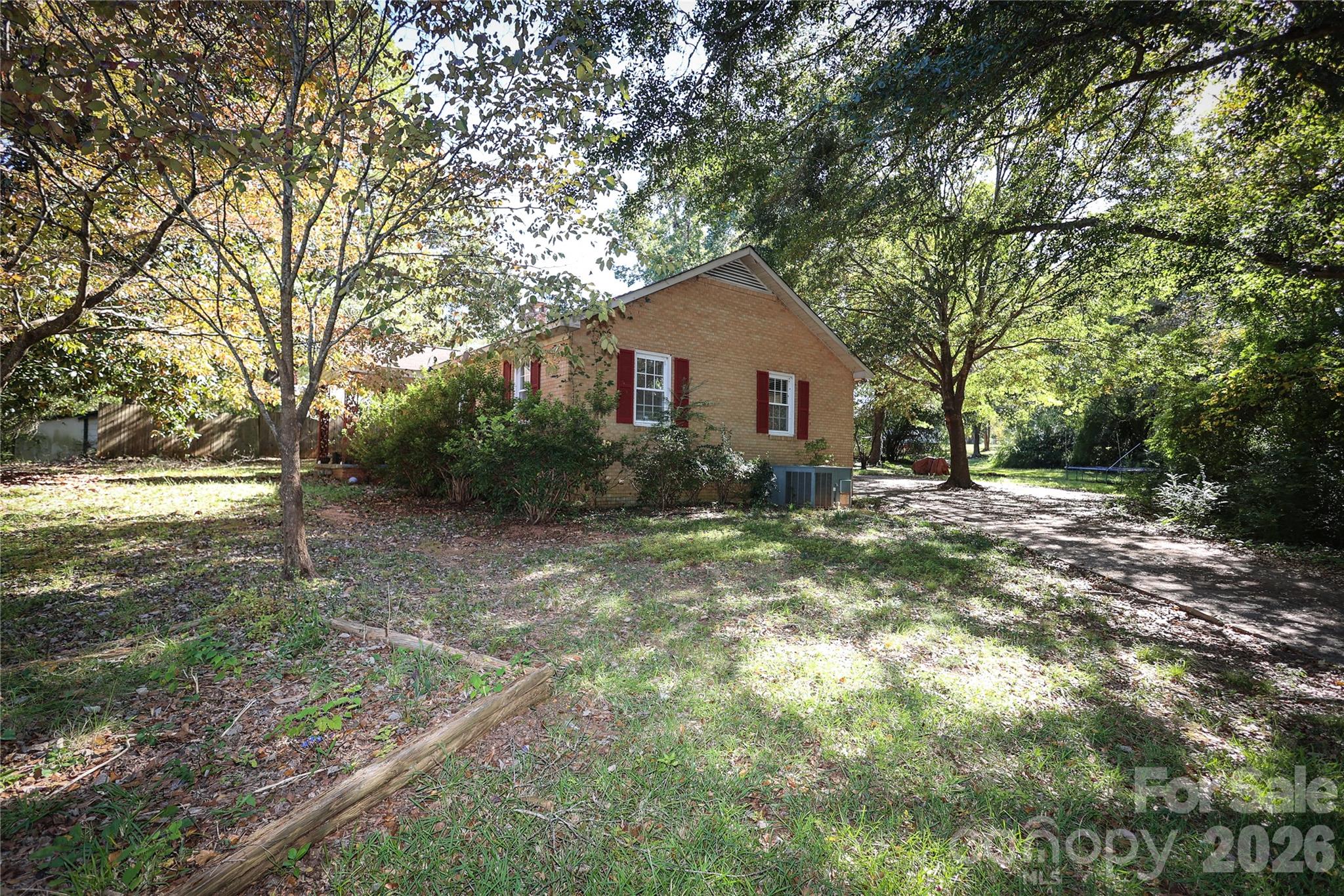 Solid, all-brick ranch with massive financial value and endless potential! Nestled on a private, tree-lined half-acre lot close to downtown Lancaster, this freshly painted 2-bedroom, 1.5-bathroom home has just been professionally deep-cleaned and is ready for its next chapter. Step inside to a bright living room with a cozy fireplace, a large eat-in kitchen with abundant cabinetry, and a flexible dining/sitting space. The primary bedroom features a unique connected bonus room—perfect for an oversized walk-in closet, home office, or nursery.

This home  Lancaster home also offers a full hall bath and a convenient half bath off the kitchen. Outside, relax in the private backyard surrounded by mature trees—perfect for outdoor entertaining, gardening, or pets. A covered 2-car carport and extended driveway with a turn-around provide easy parking and storage.

Located close to downtown Lancaster, schools, parks, and shopping, this home is ideal for buyers looking for comfort, convenience, and plenty of outdoor space in a quiet setting.  this home has an assumable mortgage through movement per the seller.